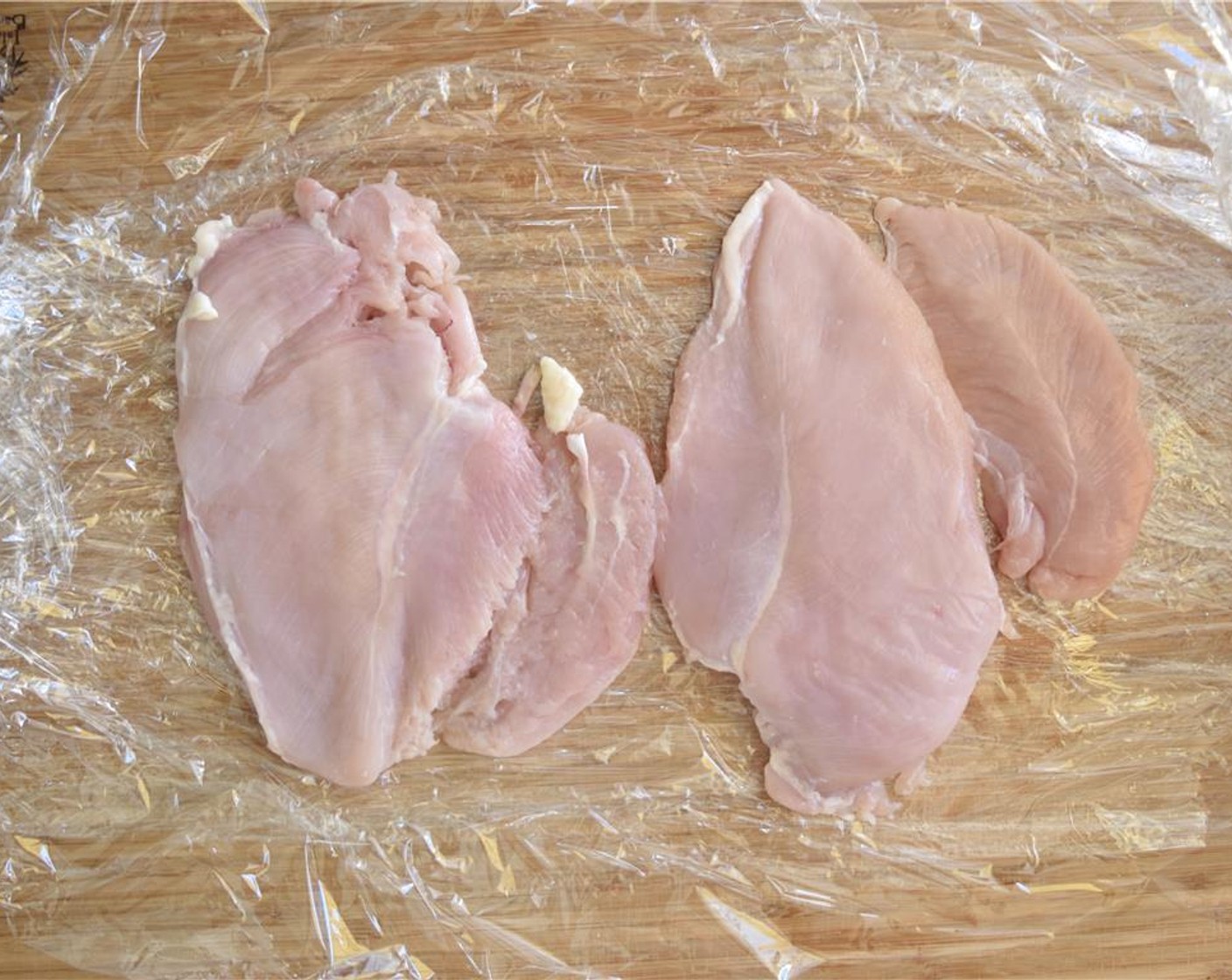 step 5 Make a layer of plastic wrap on a flat surface. Place Boneless, Skinless Chicken Breasts (2) on the wrap. Then make another layer of plastic wrap on top of the chicken. Use a heavy pan (cast iron skillet) to hit the chicken breast and flatten to about a half-inch.