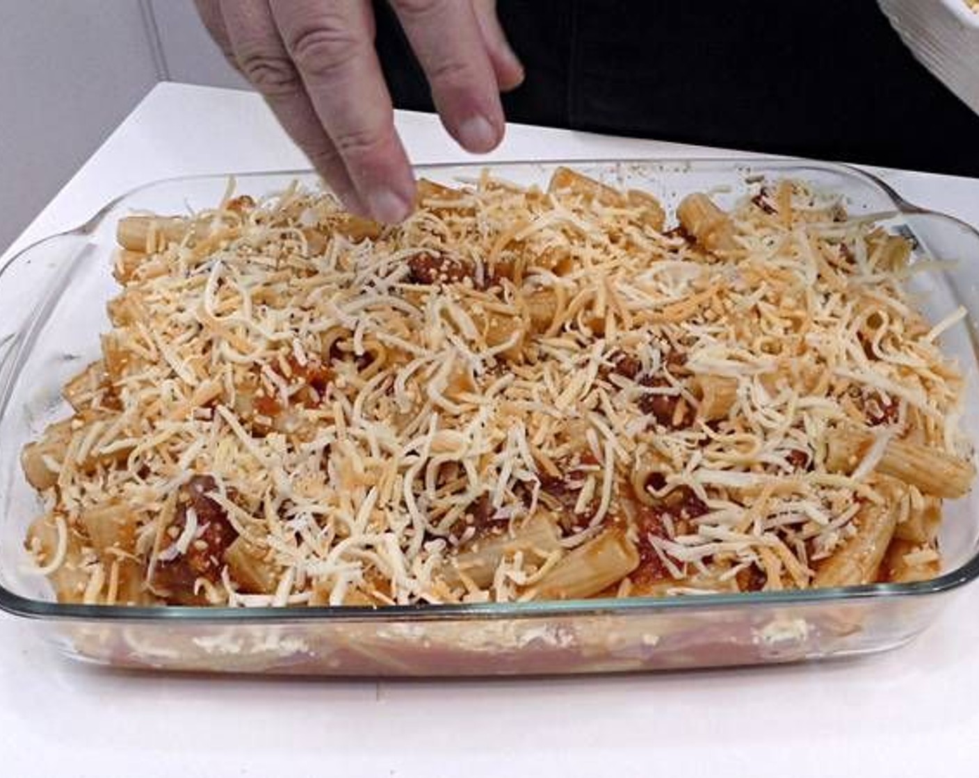 step 5 Remove the pasta and add it to a glass or ceramic baking tray and sprinkle a good amount of Shredded Cheese (to taste) on top.