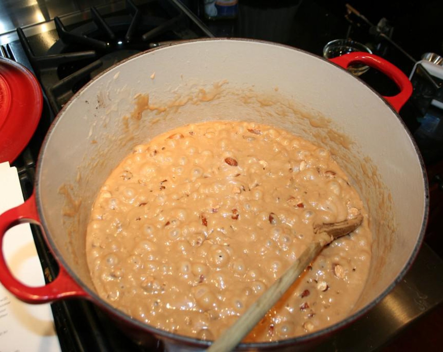 step 5 Once your temperature reaches about 280 degrees F (137 degrees C) or so add your Vanilla Extract (1/2 Tbsp) and roughly chopped almonds to your sugar mixture. This will bring down your temperature. Continue to stir vigorously at this point it will look like it as separated but continue to stir and it will all come together and bring it up to 300 degrees F (150 degrees C). Once it reaches 300 degrees F (150 degrees C) remove from heat and continue to stir for about 5 minutes.