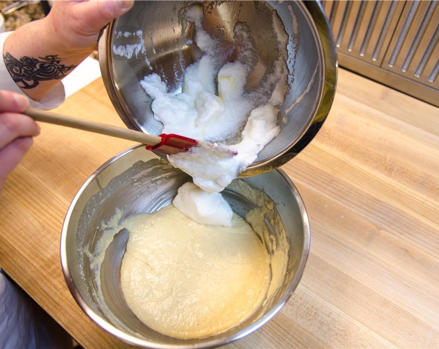 step 7 With a rubber spatula, mix a dollop of stiff eggs whites into the yolk mixture to lighten the mix.