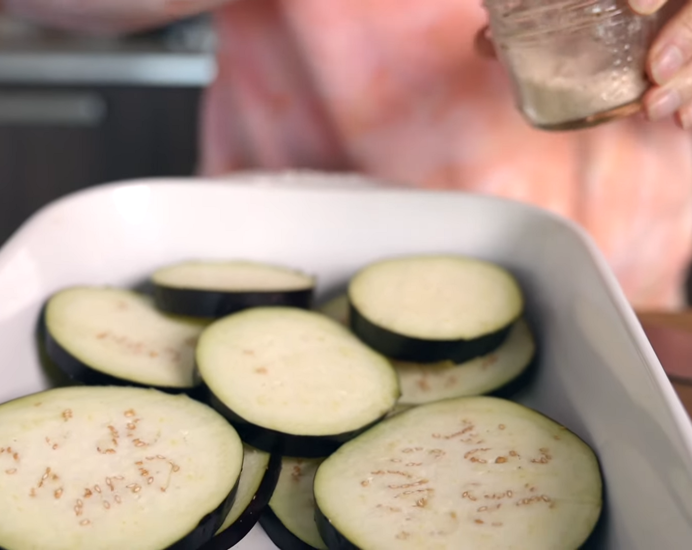 step 5 Place a layer of Eggplants (2) in the baking dish. Sprinkle with Fine Sea Salt (1 tsp) to draw out excess moisture. Continue adding layers of eggplant and sprinkling with salt. Let sit for 10 minutes.