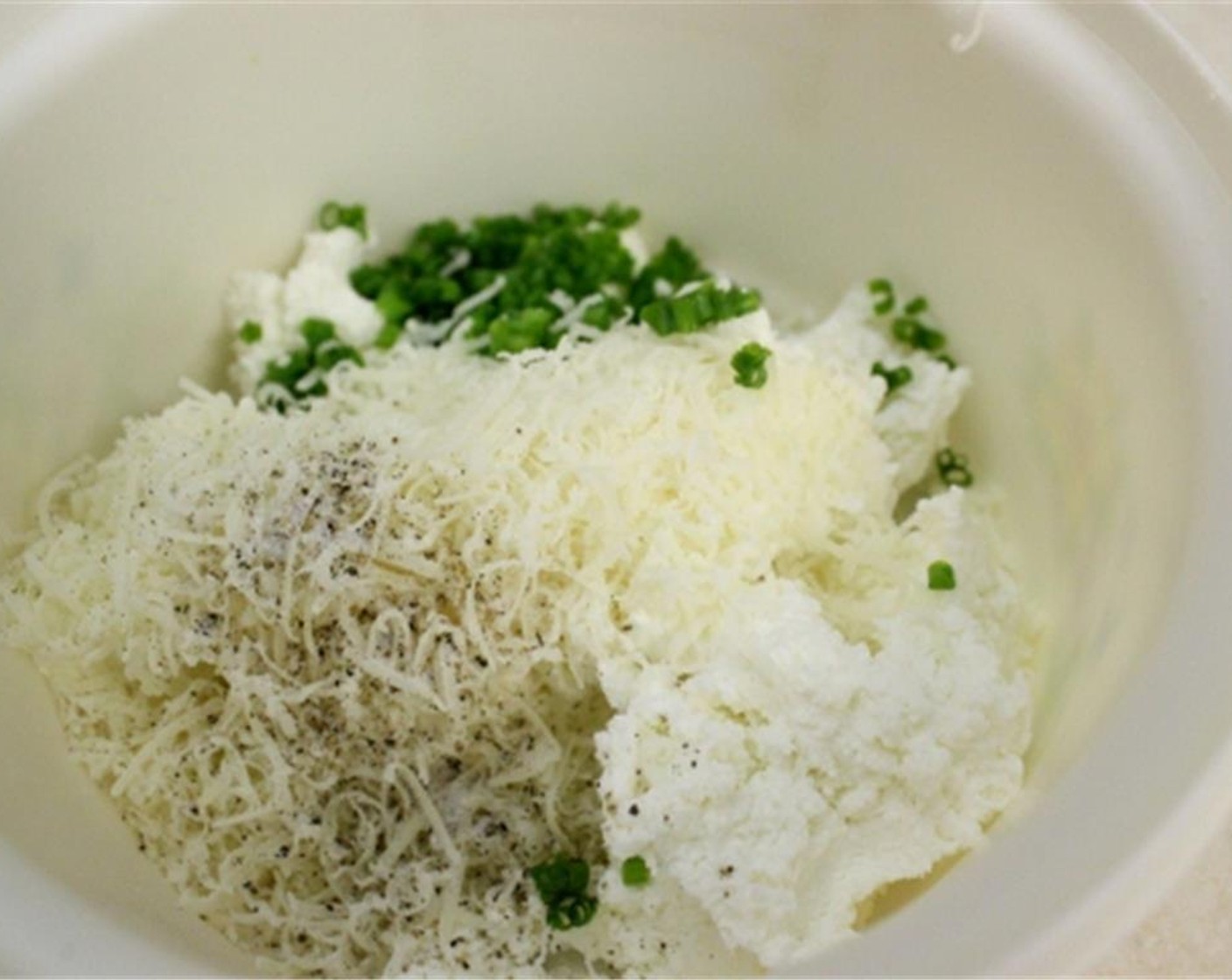 step 3 For the cheese filling, combine in another bowl the Farmers Cheese (1/2 cup), Mozzarella Cheese (1 cup), Fresh Parsley (to taste), Fresh Chives (to taste), and Heavy Cream (2 Tbsp). Season with Salt (to taste) and Ground Black Pepper (to taste). Mix to combine.