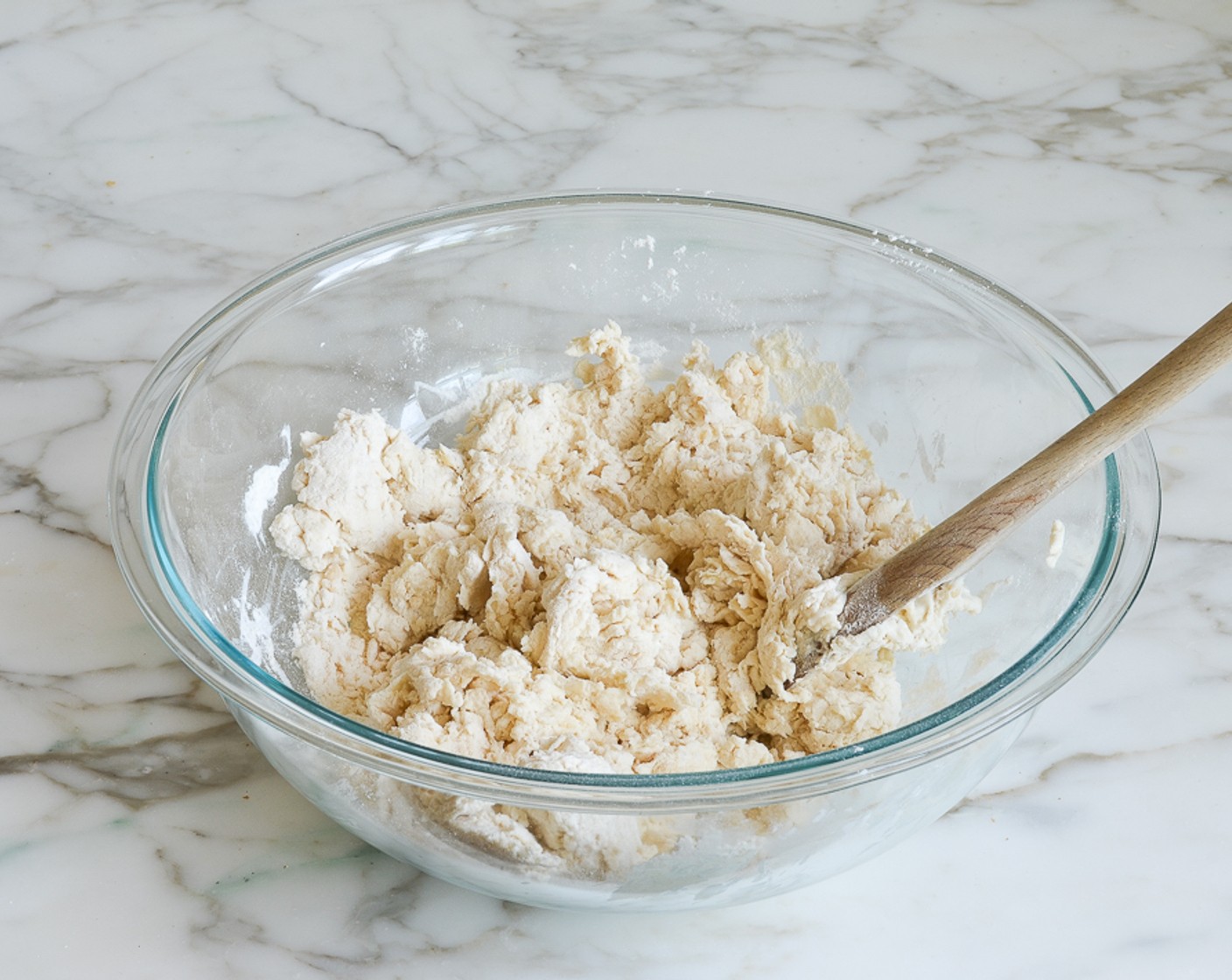 step 5 Add Unsalted Butter (3 Tbsp) and Low-Fat Buttermilk (1 1/4 cups) to the dry ingredients and stir with a wooden spoon until the liquid is absorbed (the dough will be sticky and look shaggy), about 30 seconds.