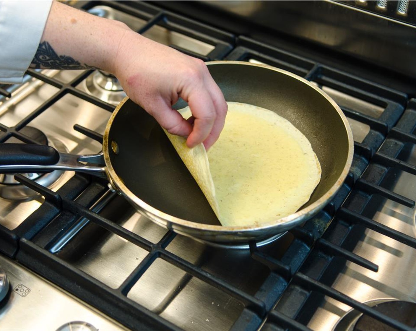 step 8 Using a thin spatula, tongs, or carefully using your fingers, flip the crepe over and continue to cook until lightly browned, about 1 minute.