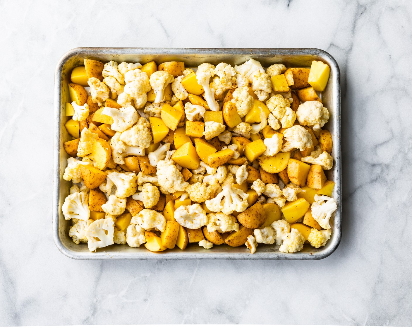 step 2 Toss prepared Red Potatoes (3 cups) and Cauliflower Florets (4 cups) in Oil (2 Tbsp), Ground Cumin (1 tsp), Salt (to taste), and Ground Black Pepper (to taste).