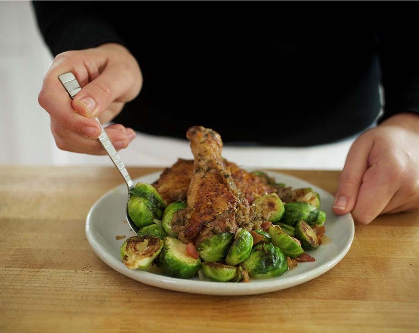 step 16 In the center of two plates, evenly divide the brussels sprouts mixture. Place two pieces of half bone in chicken over vegetable mixture and spoon sauce from pan over chicken.