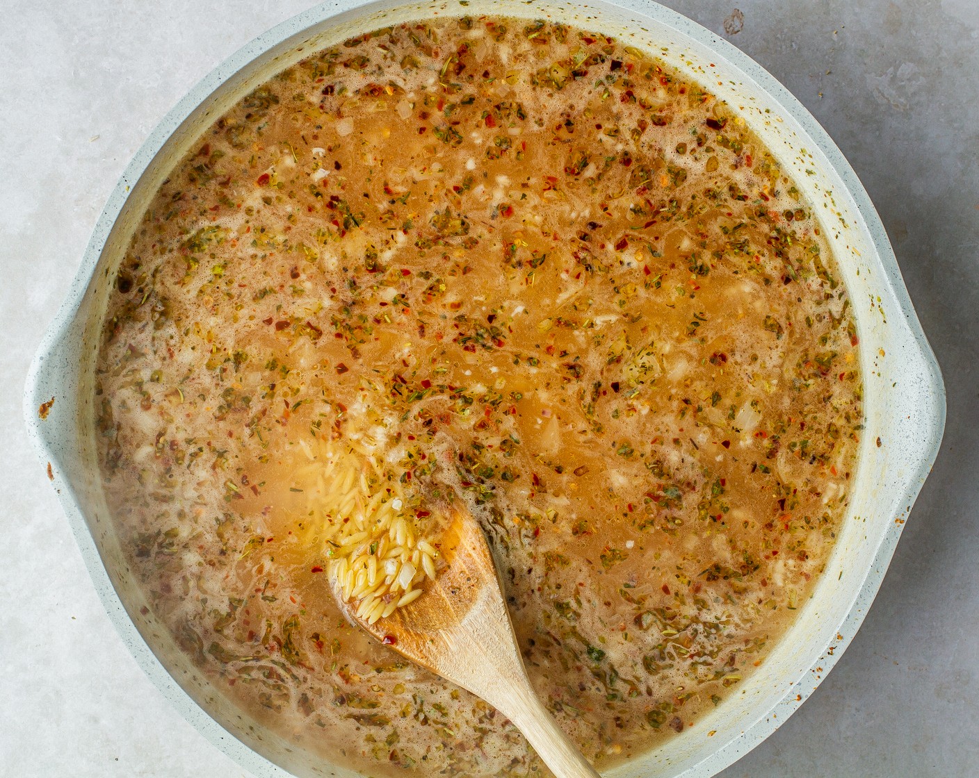 step 5 Stir Unsalted Butter (2 Tbsp), Kosher Salt (1 tsp), Ground Black Pepper (1/2 tsp), Italian Seasoning (1 tsp), Crushed Red Pepper Flakes (1 tsp), Vegetable Stock (4 cups), and the juice from Lemon (1). Increase heat to high and bring the liquid to a boil.