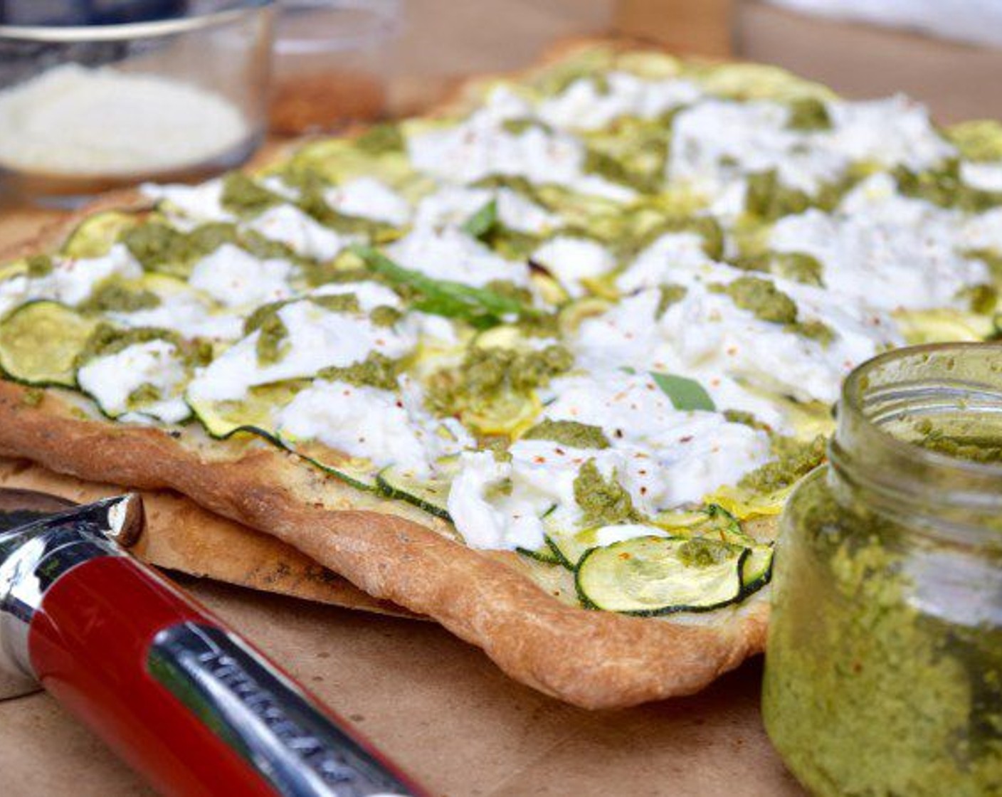step 7 Remove the pizza from the oven and break two balls of Burrata over the pizza. Drizzle all over with Basil Pesto (to taste). Allow the Burrata Cheese (2 cups) to rest on the pizza for about 2 minutes before serving. The heat from the pizza will help it to warm through.