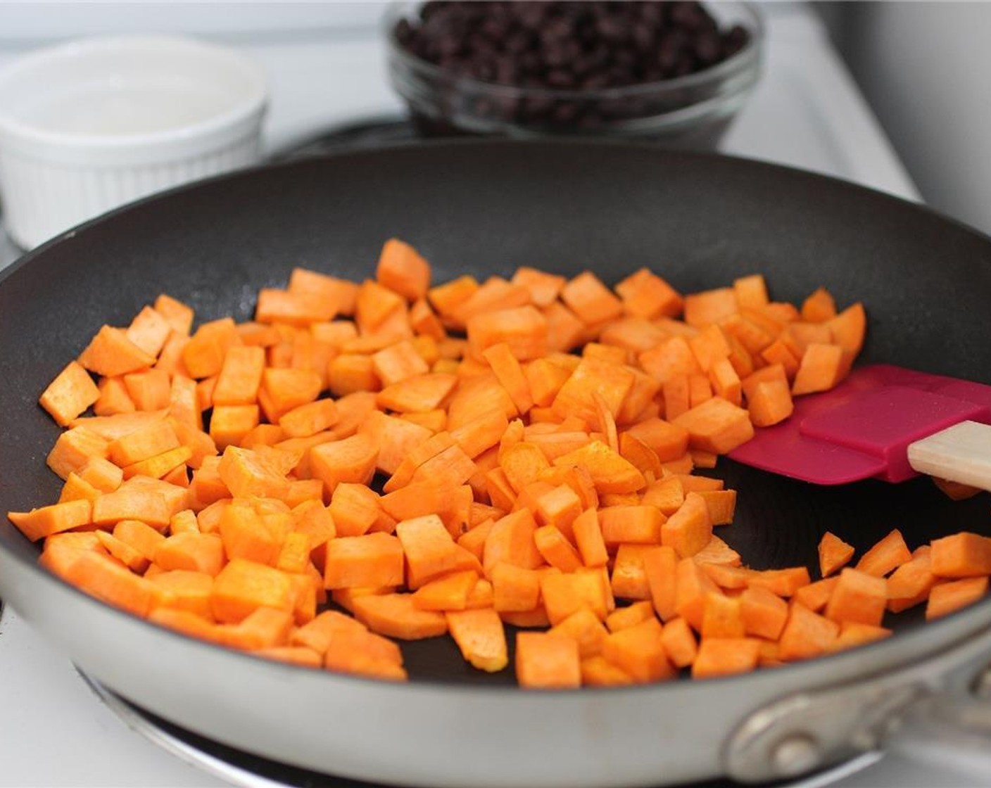 step 3 Sauté Sweet Potato (1) in a greased skillet over medium heat until they start to brown a bit. I like to use spray olive oil to keep the amount of oil down.