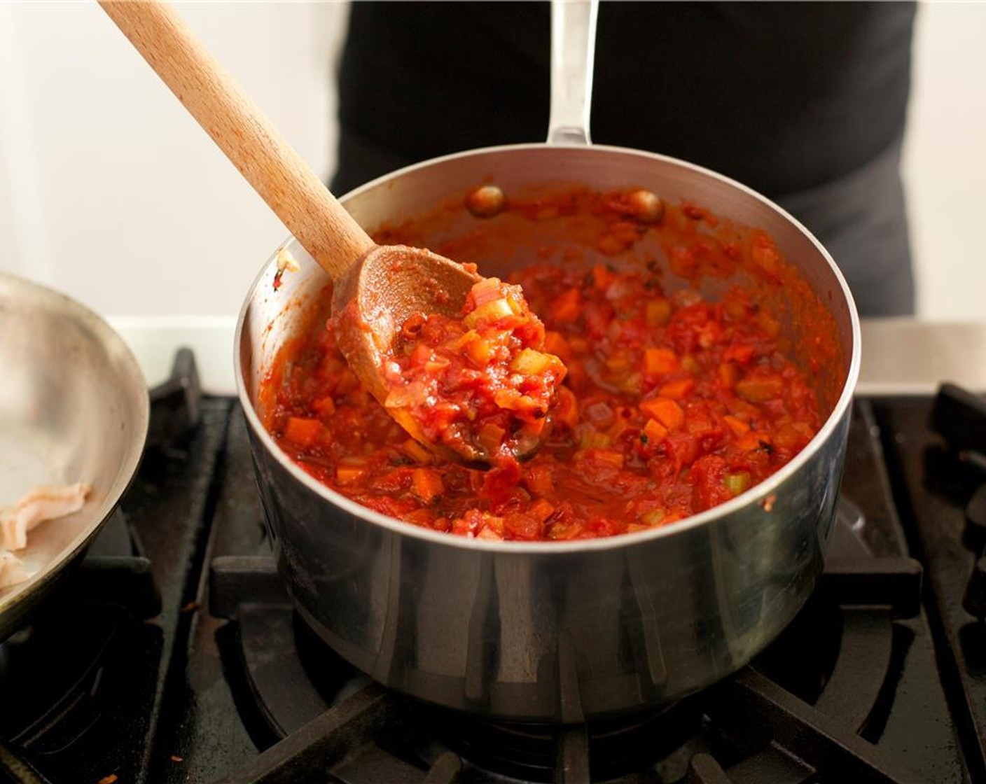 step 9 Add the Canned Crushed Tomatoes (3 1/3 cups), Crushed Red Pepper Flakes (1 tsp), and Ground Black Pepper (1/4 tsp) and reduce heat to low. Cook uncovered for fifteen minutes, stirring occasionally.