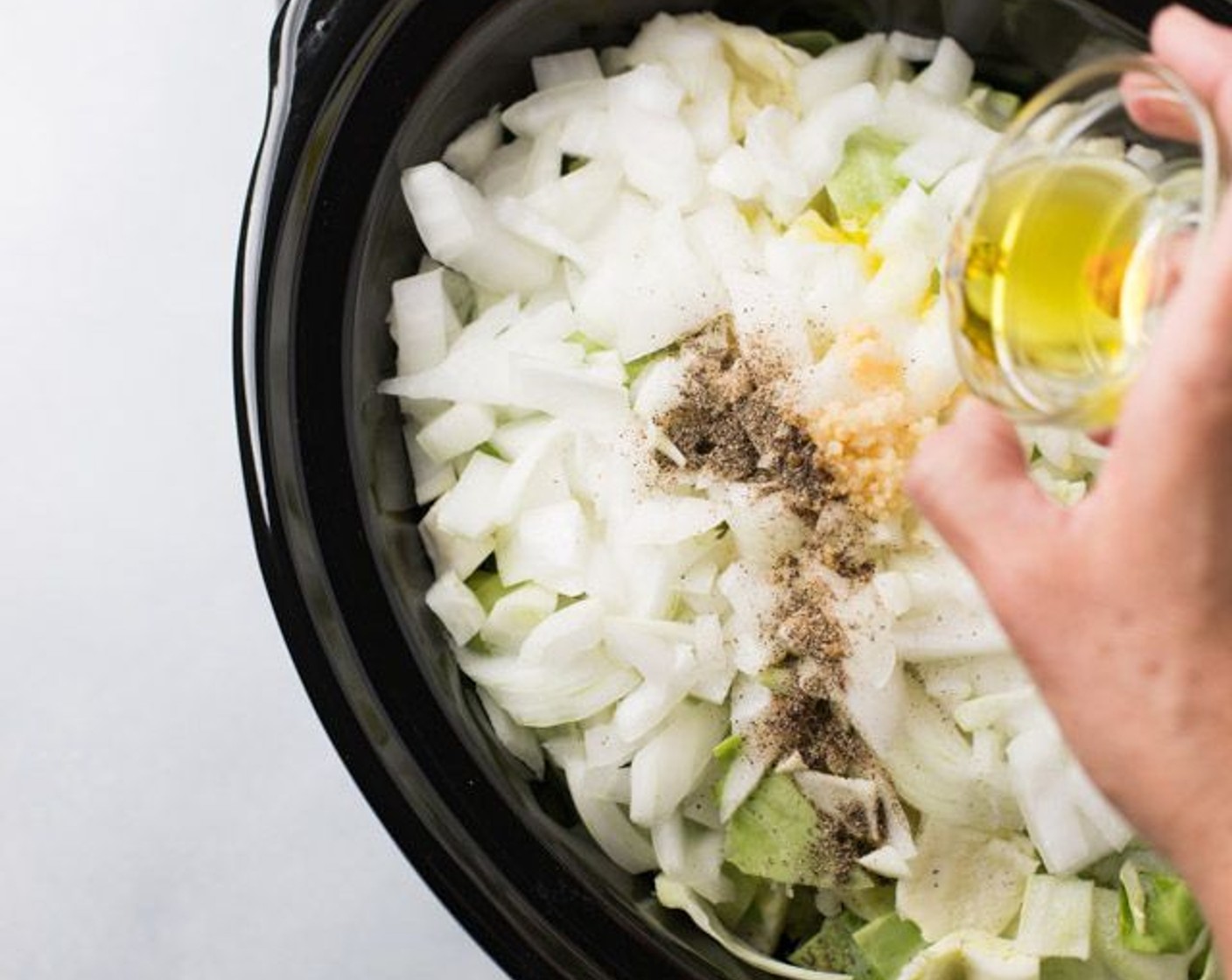 step 3 Add green cabbage, sweet onion, Garlic (1 tsp), Olive Oil (1 Tbsp), Water (3 Tbsp), Salt (1 Tbsp) and Freshly Ground Black Pepper (1/2 tsp) to your slow cooker.