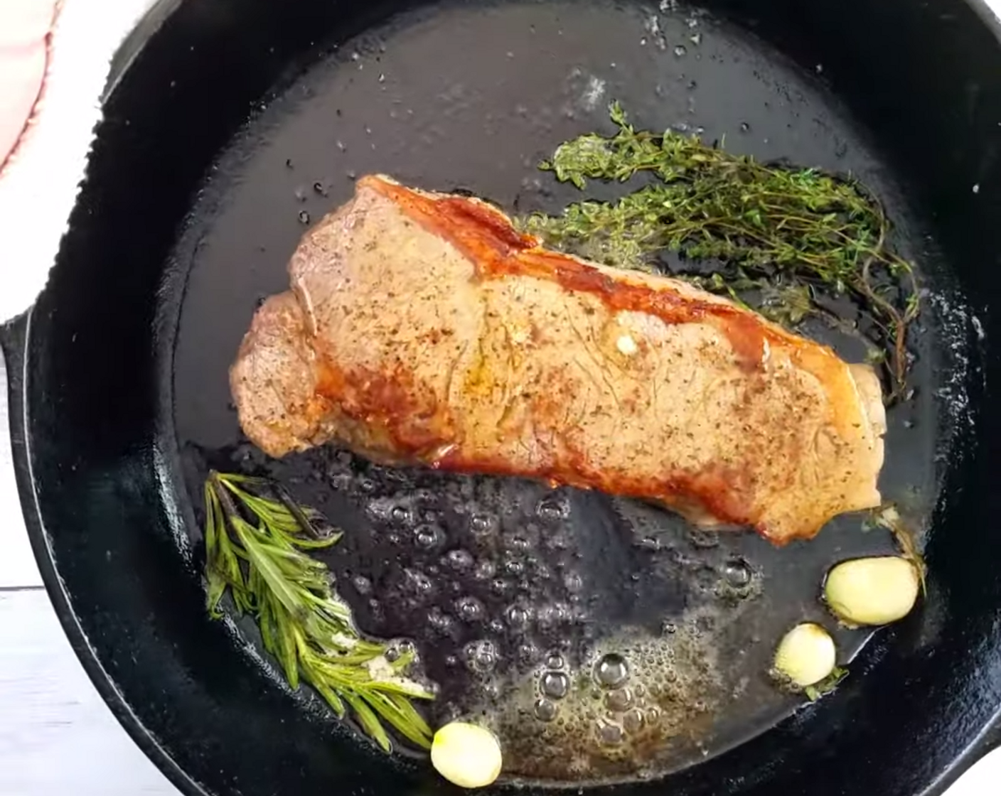 step 5 Add fresh herbs Fresh Thyme (1 sprig), Fresh Rosemary (1 sprig), and Garlic (1 clove) to the pan along with more Extra-Virgin Olive Oil (1 Tbsp) and Butter (1 Tbsp). While the steak is grilling, baste the steak with the herb-seasoned butter.
