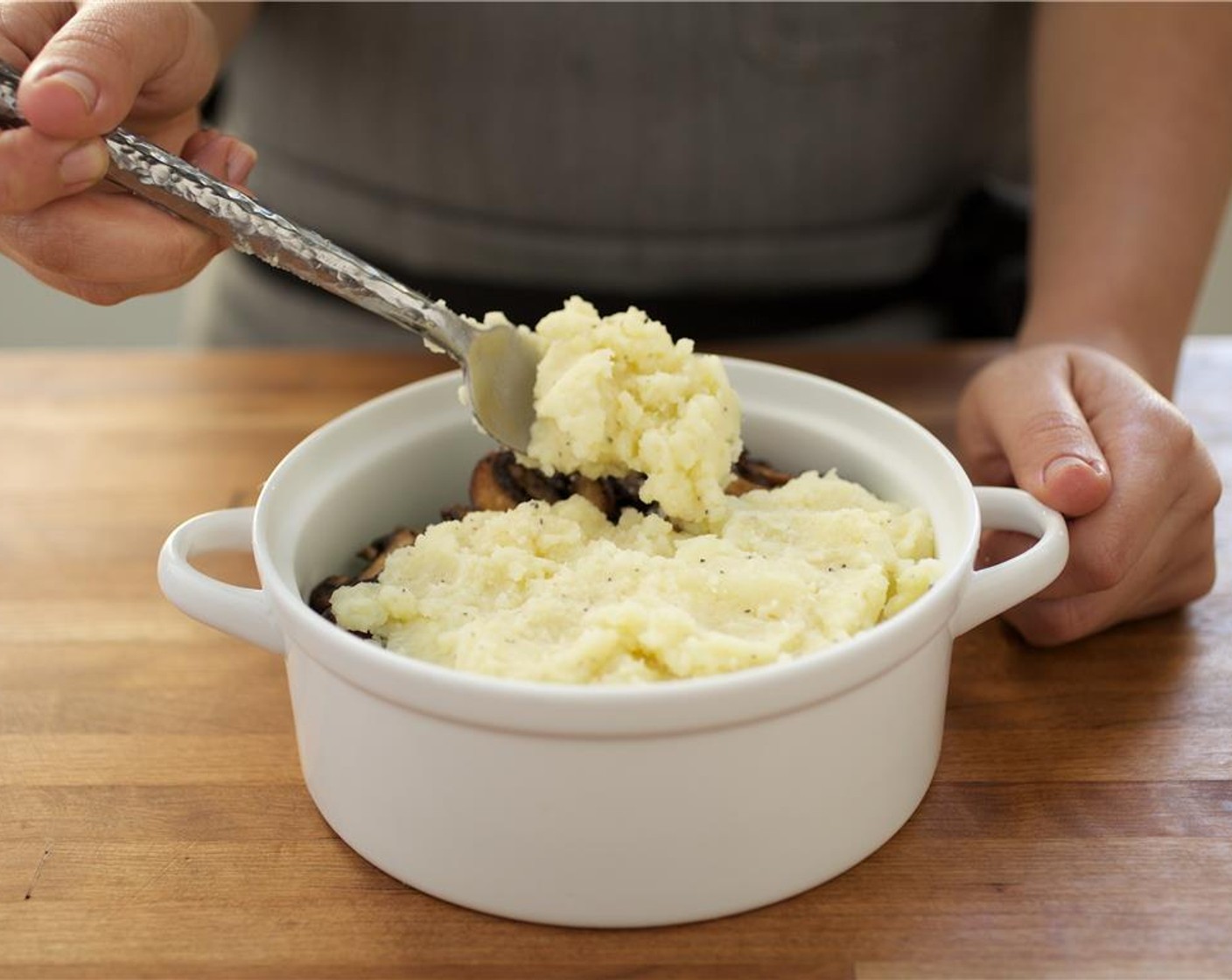 step 12 In an oven-safe baking dish spread the beef mixture evenly amongst the bottom of the dish. Then, cover evenly with Green Peas (1/2 cup) and mushrooms. Spread only 2 cups of mashed potatoes over peas and mushrooms. Crumble with the remaining Butter (1 1/2 Tbsp).