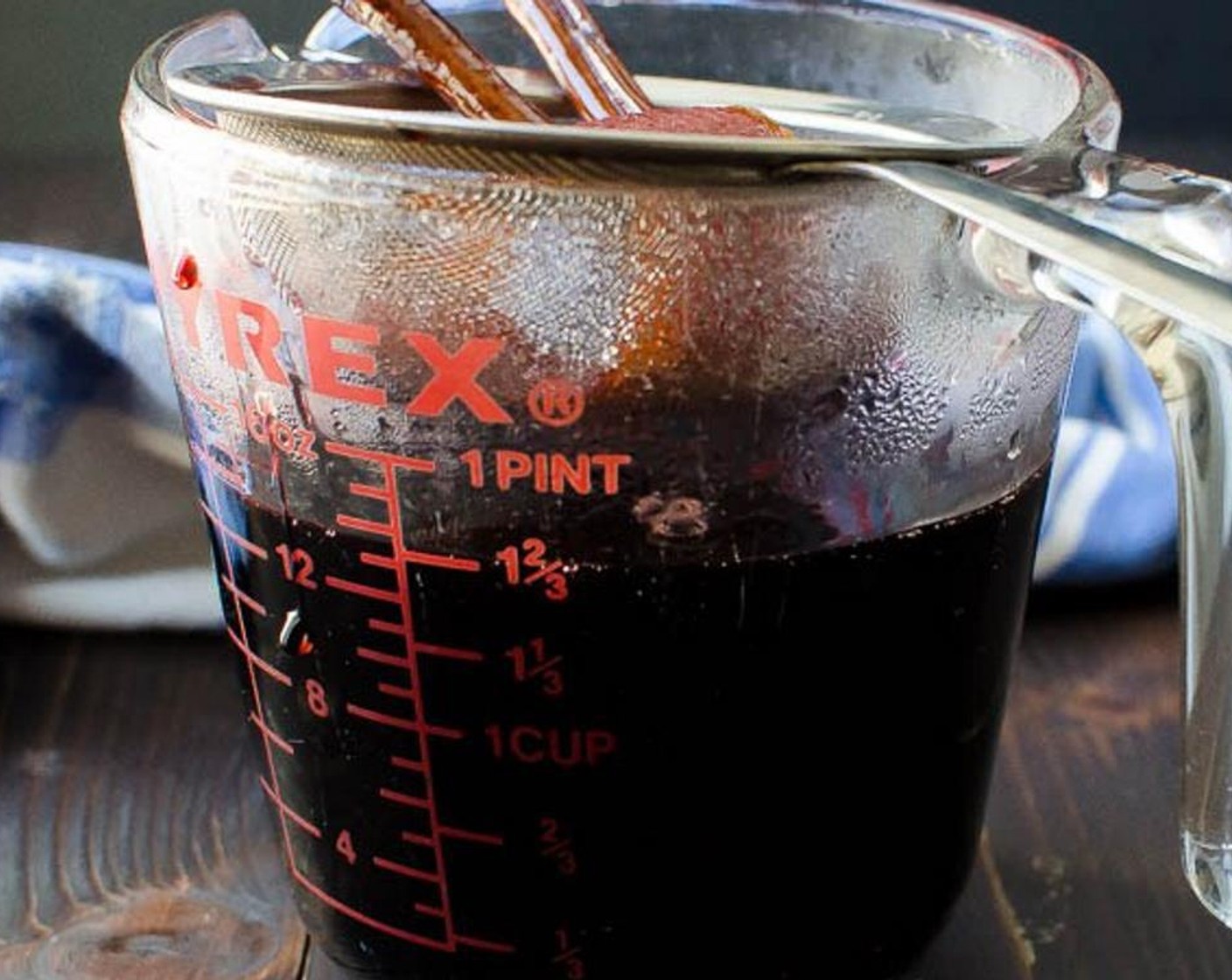 step 3 Place a fine mesh strainer over a 2 cup measuring cup and pour the syrup through. Discard the solids and pour the syrup back into the pot.