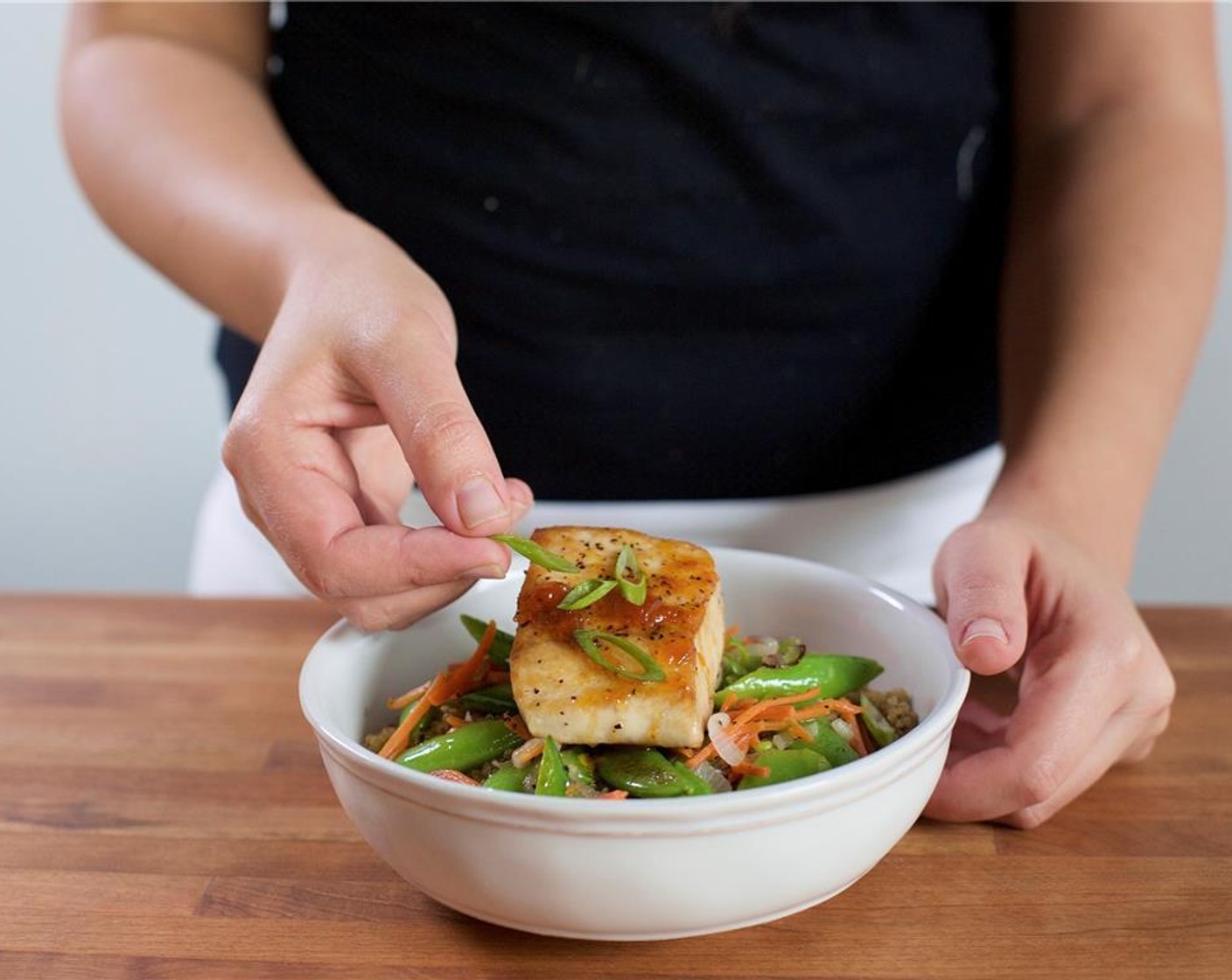 step 10 In the center of two bowls, place the quinoa. Add the vegetables directly over the quinoa. Place the mahi mahi in the center. Spoon the glaze over the fillets. Garnish with remaining green onions.