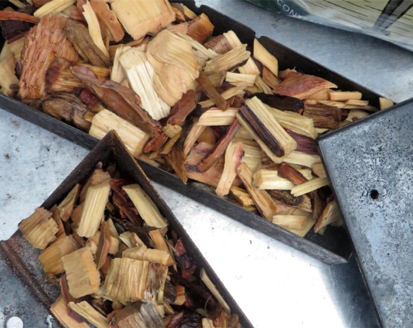 step 9 Adjust vents on top of the grill to half open. When adjusted properly, the grill will be 325-350 degrees F (160-180 degrees C). Toss the drained wood chips onto the coals (about 1/2 cup on each side of the grill).