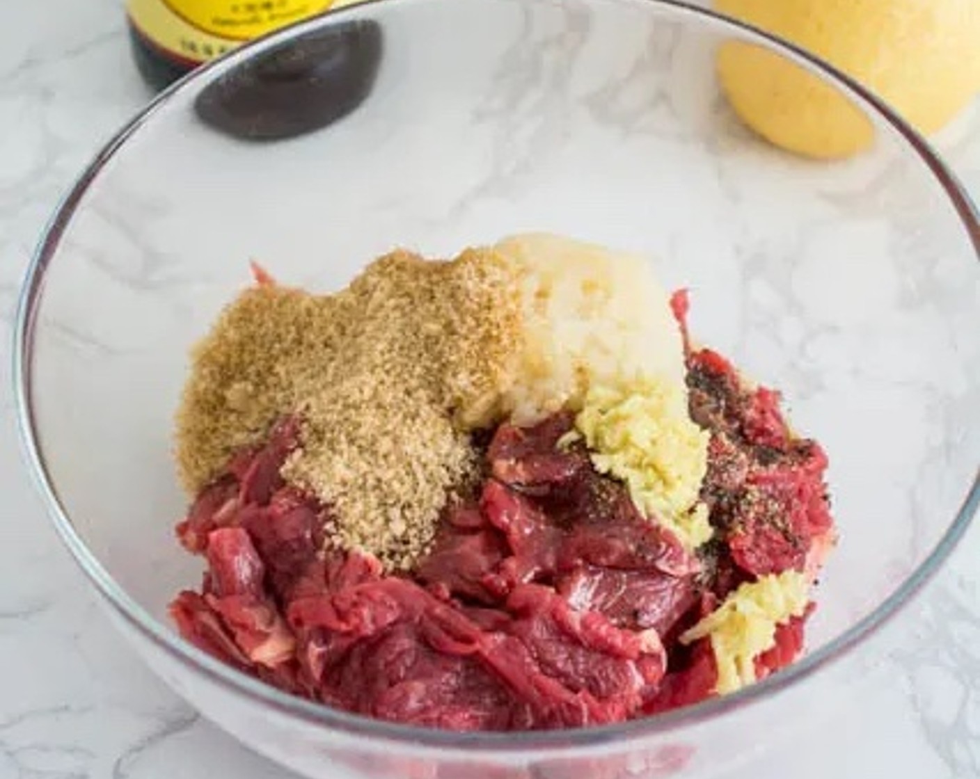 step 2 Add Light Soy Sauce (3 Tbsp), Sesame Oil (2 Tbsp), Brown Sugar (2 Tbsp), Asian Pears (2 Tbsp), Fresh Ginger (1 tsp), and Ground Black Pepper (1 dash) to the beef. Mix thoroughly, then cover the bowl with plastic wrap.