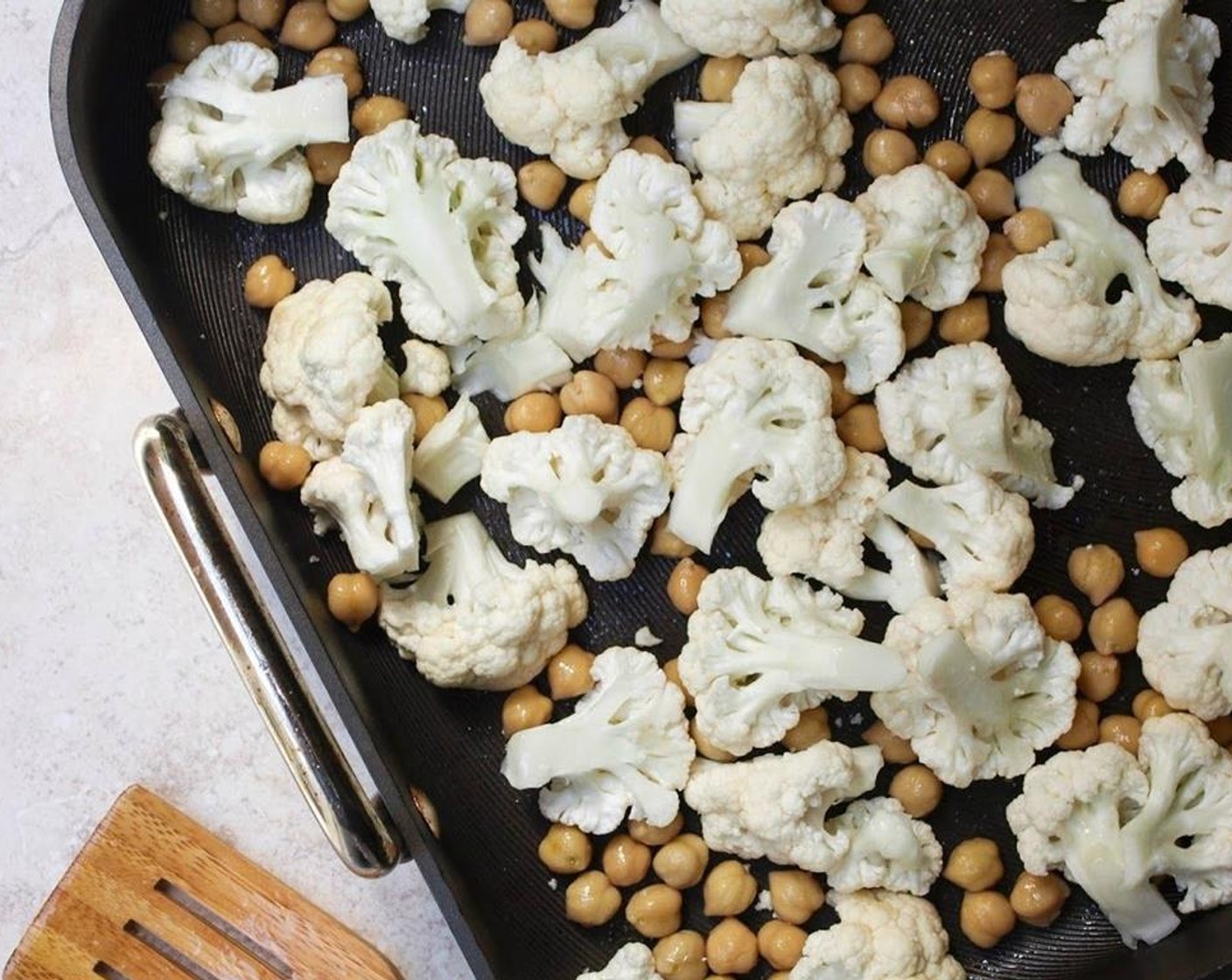 step 2 Toss the Chickpeas (1 can) and Cauliflower (1) together in a large roasting pan with Olive Oil (1 Tbsp) and dash or two of Mineral Salt (to taste). Roast for 45 minutes, stirring every 15 minutes or so.