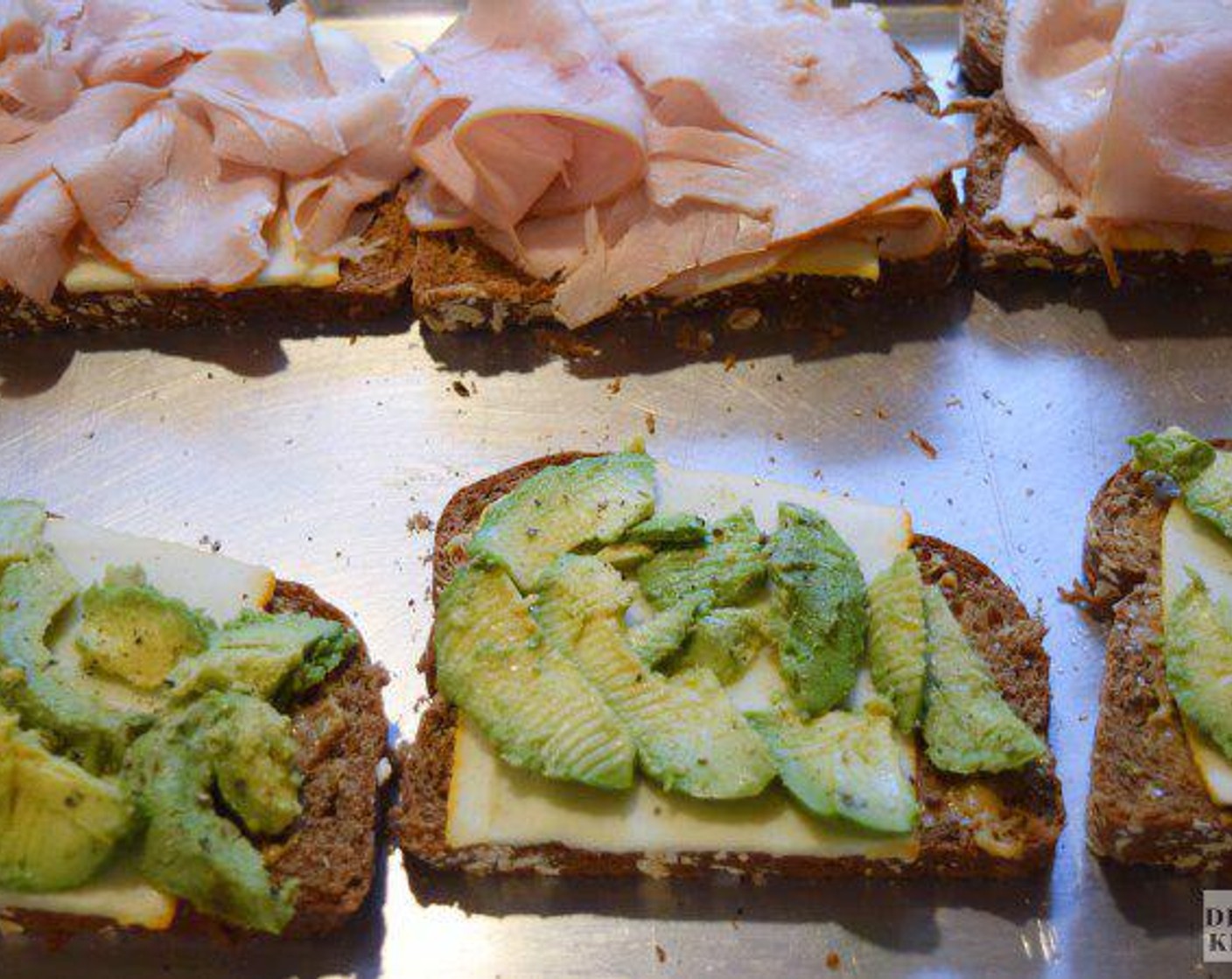 step 2 Then, lay one Provolone Cheese (2 slices) on each piece of bread. Pile on your favorite Turkey (2 oz), and Avocado (1/2). Top with the other slice of bread and begin preheating a cast iron skillet over medium heat.