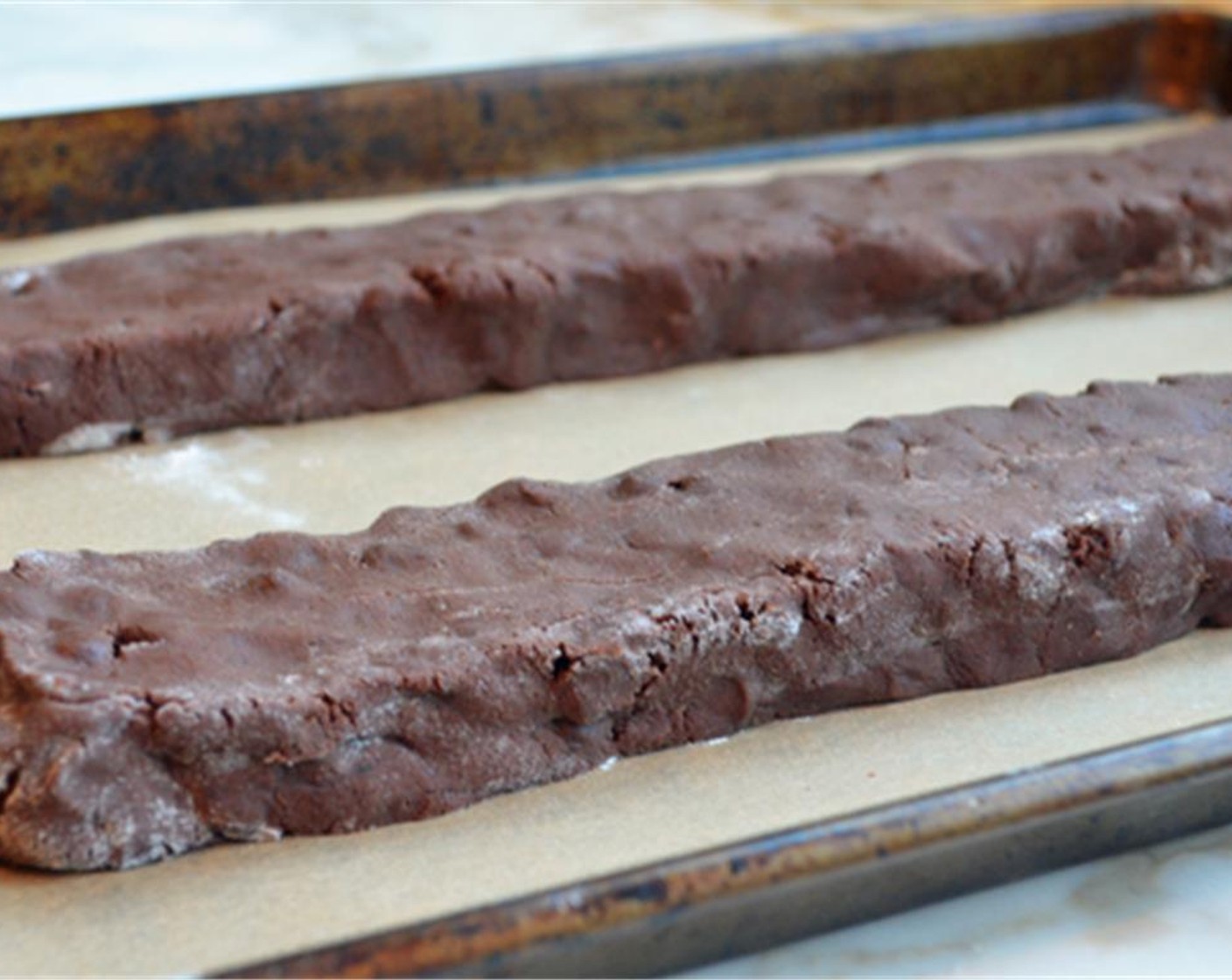 step 8 Place the logs onto the prepared baking sheet and shape into longer logs about 3/4 inch high and 2 inches wide. Allow enough space for the logs to spread a few inches while they bake.