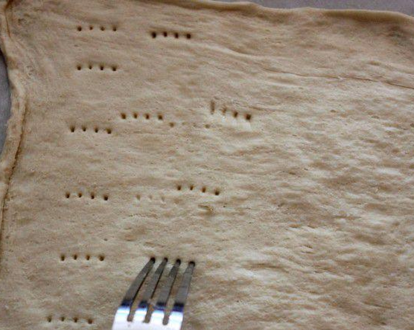 step 1 Lay out the Crescent Dough Sheet (1 pckg) spread out thinly, on a parchment lined baking sheet.  With a fork, gently poke shallow holes throughout the dough.