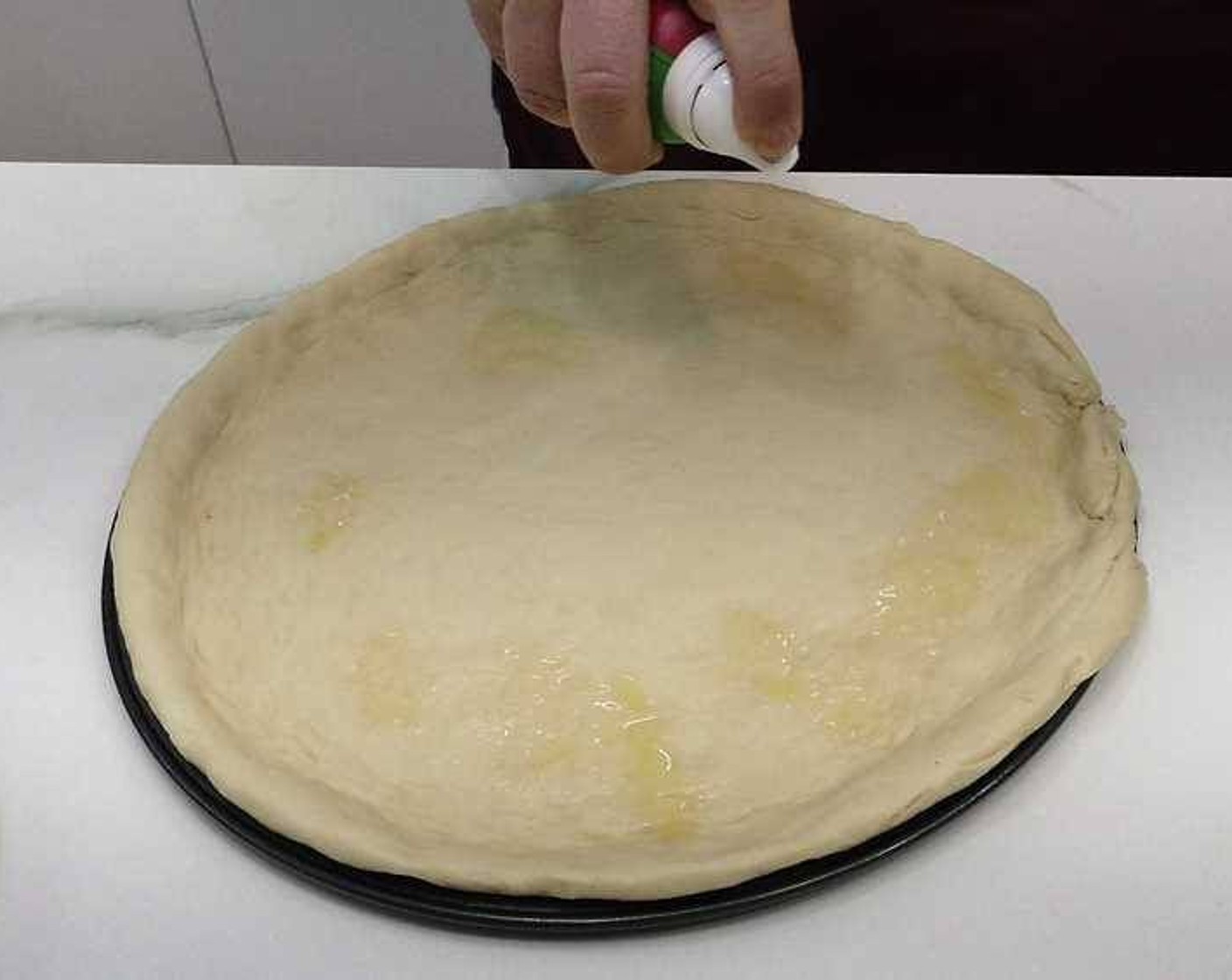 step 1 Spread the Pizza Dough (to taste) over a large round pan. Drizzle Olive Oil (as needed) on top.