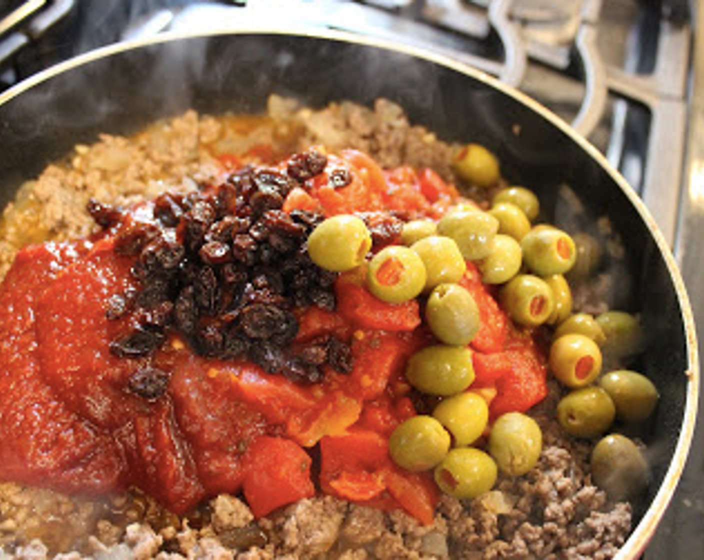 step 3 Add Ro-Tel® Diced Tomatoes & Green Chilies (1 can), Chili Sauce (3/4 cup), Water (1/2 cup), Pimento Stuffed Green Olives (1/2 cup), Raisins (1/4 cup), Salt (to taste), and Ground Black Pepper (to taste).