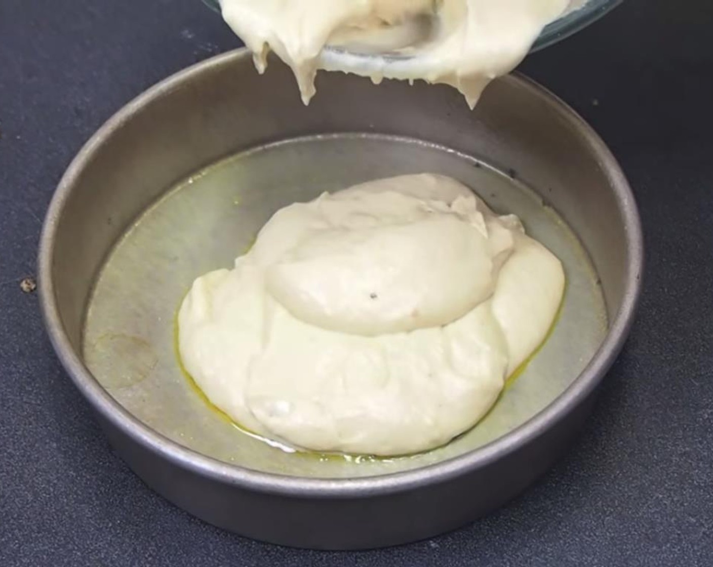 step 4 In a greased cake pan, spoon in half the batter.