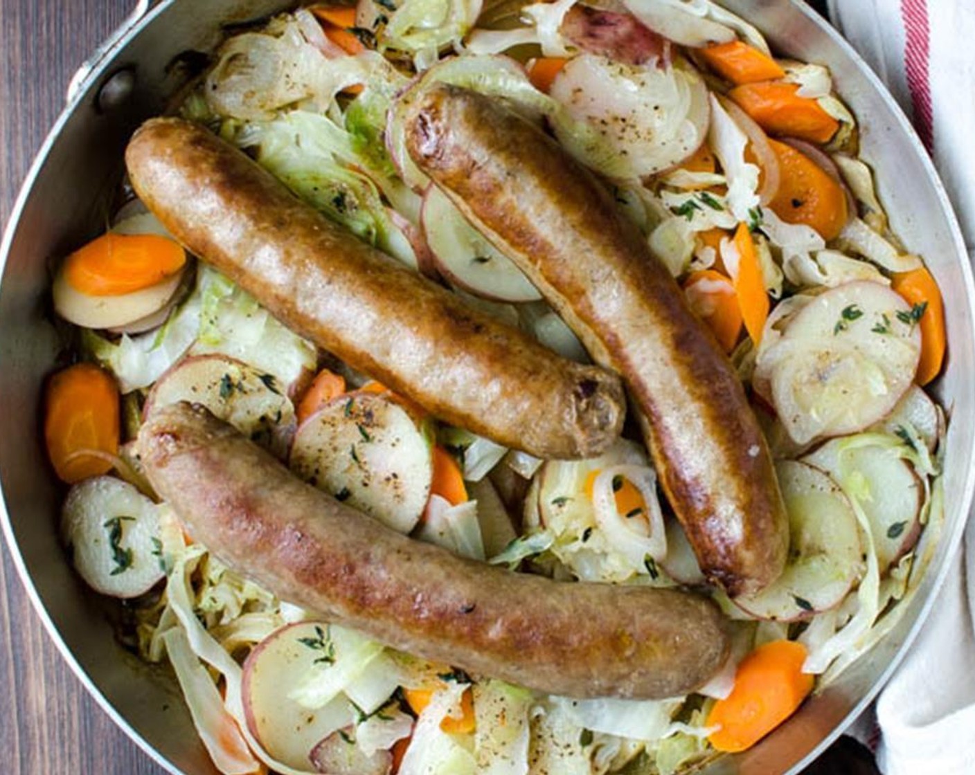 step 4 After the vegetables have cooked for 10 minutes, nestle the sausages into the potato mixture, along with any accumulated juices. Add the remaining Low-Sodium Chicken Broth (3/4 cup) and Fresh Thyme (1 tsp), then cover and cook for an additional 10 minutes, or until potatoes and carrots are very tender.