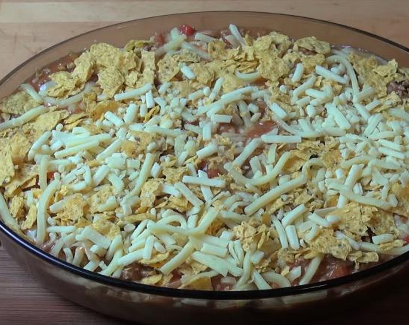 step 4 In a lightly greased oven-proof casserole dish, cover the bottom with Corn Chips (8 1/3 cups), followed by half of the beef mixture and half of the Cheese (2 cups). Repeat the layers once more.