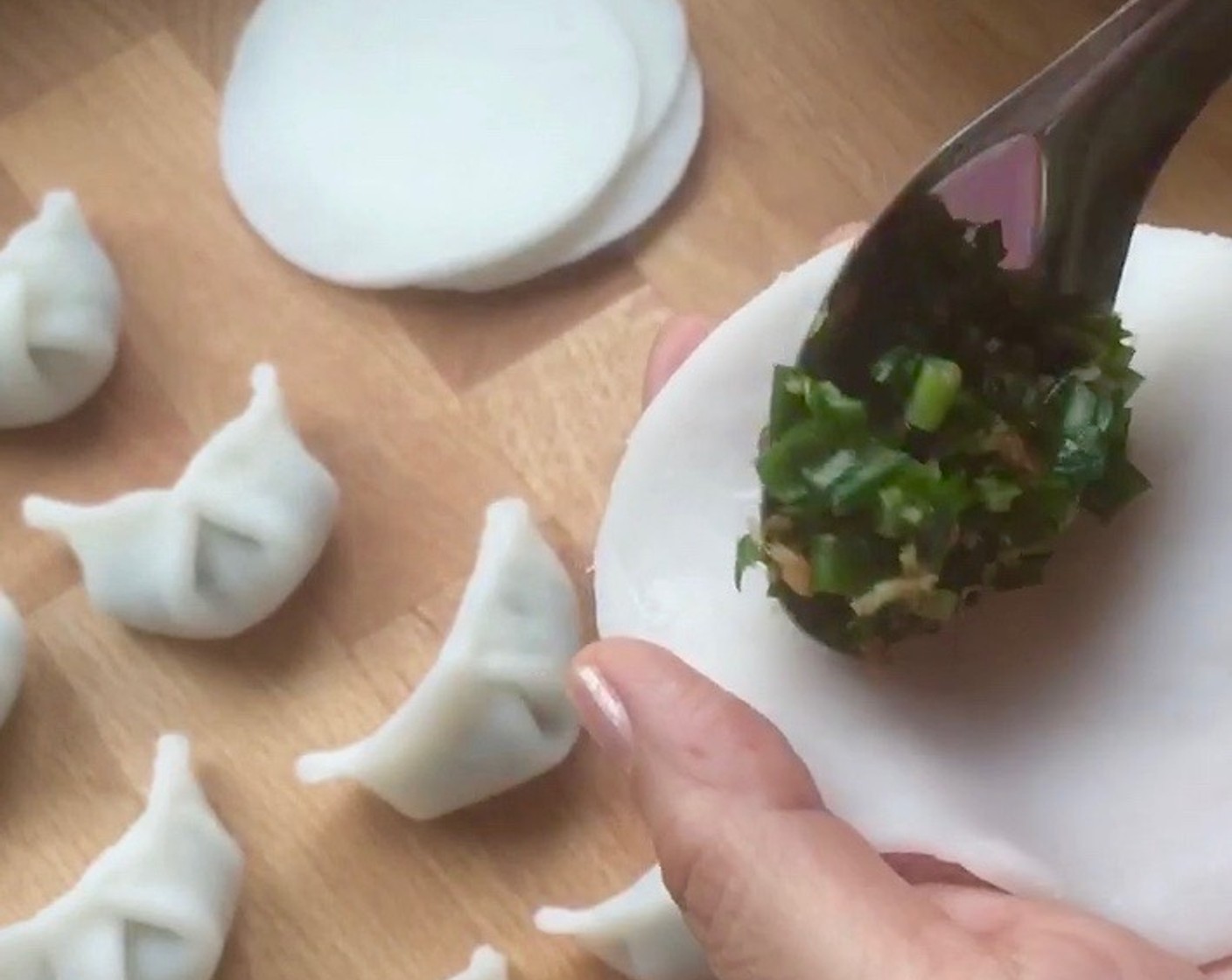 step 17 To make the dumplings, first spoon 1 heaping tbsp chive filling into the centre of wrapper.