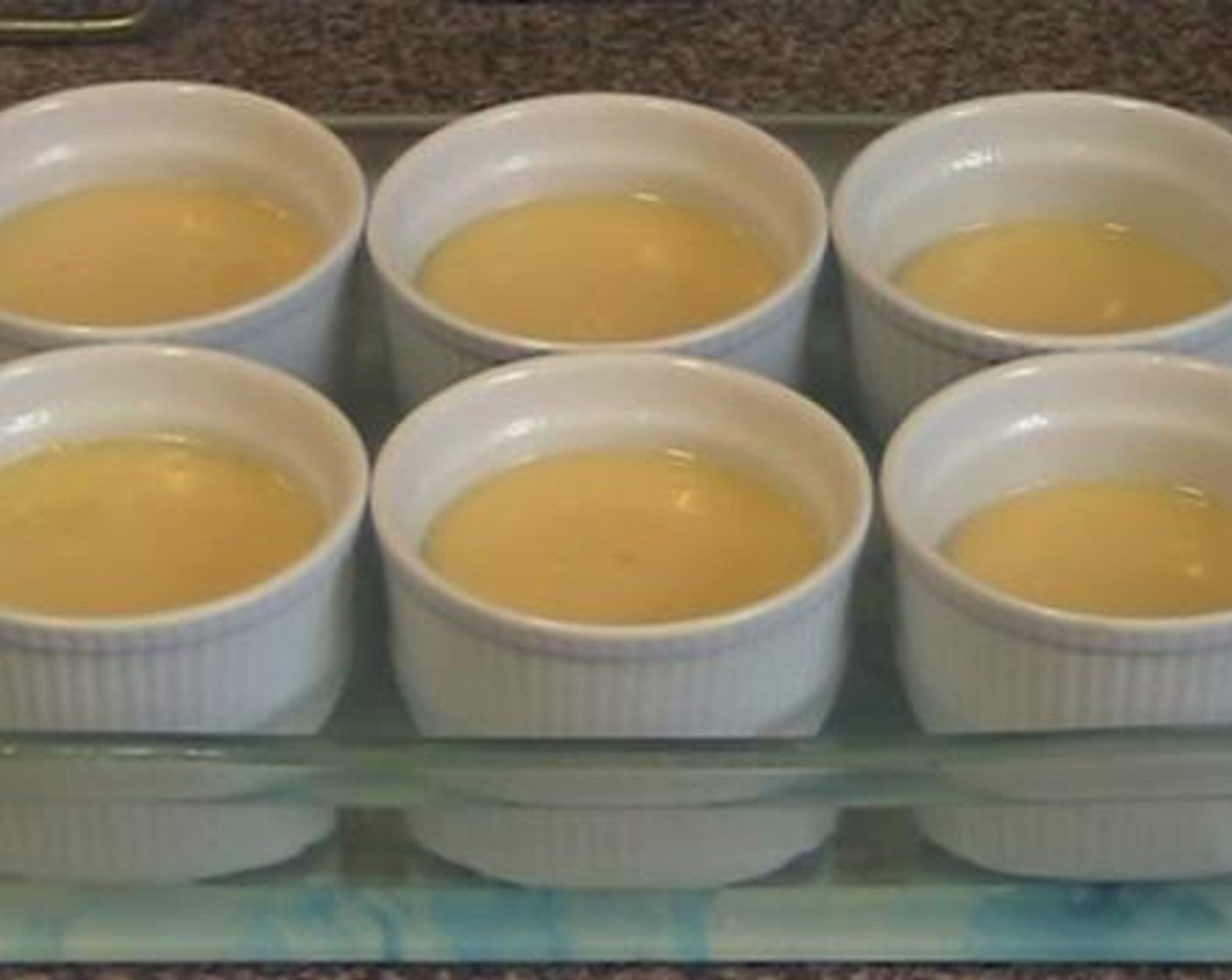 step 3 Divide the pudding mixture between 6 greased baking cups. Line up the cups inside a baking dish and fill in the dish with boiling water until it is halfway through the height of each cup. Bake inside a preheated oven under 180 degrees C (350 degrees F) for about 1 hour.