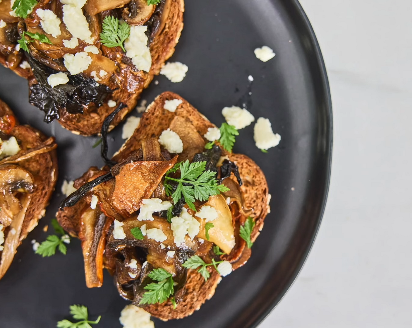 step 9 Spoon a generous amount of the mushroom mixture equally onto each slice of toasted bread. Top with Crumbled Feta Cheese (to taste) and Fresh Parsley (to taste) to each piece. Best served hot so enjoy right away!