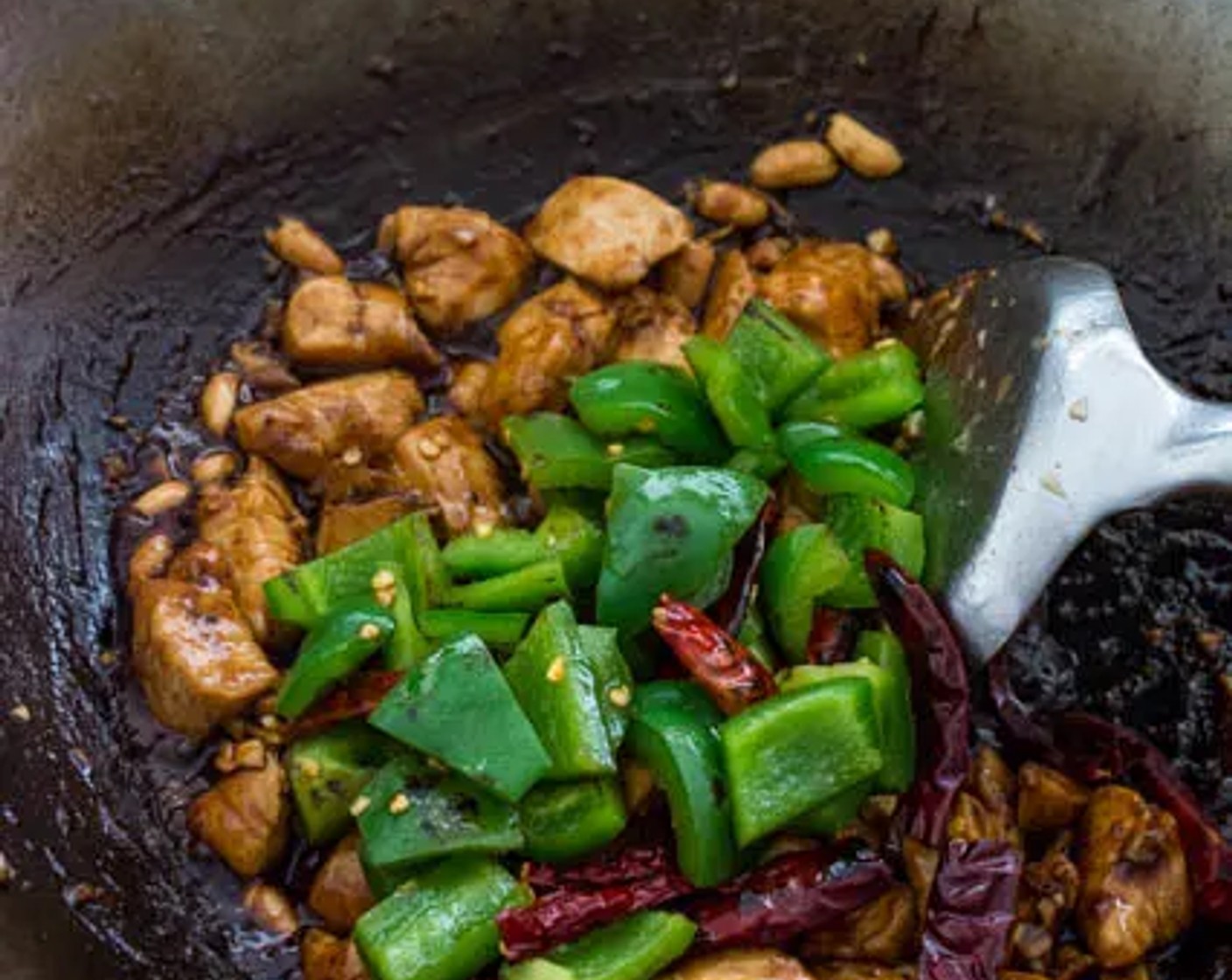 step 7 Give the sauce a quick stir, then pour all of the sauce into the wok. Return the bell pepper and chilies to the wok. Stir to combine all ingredients.