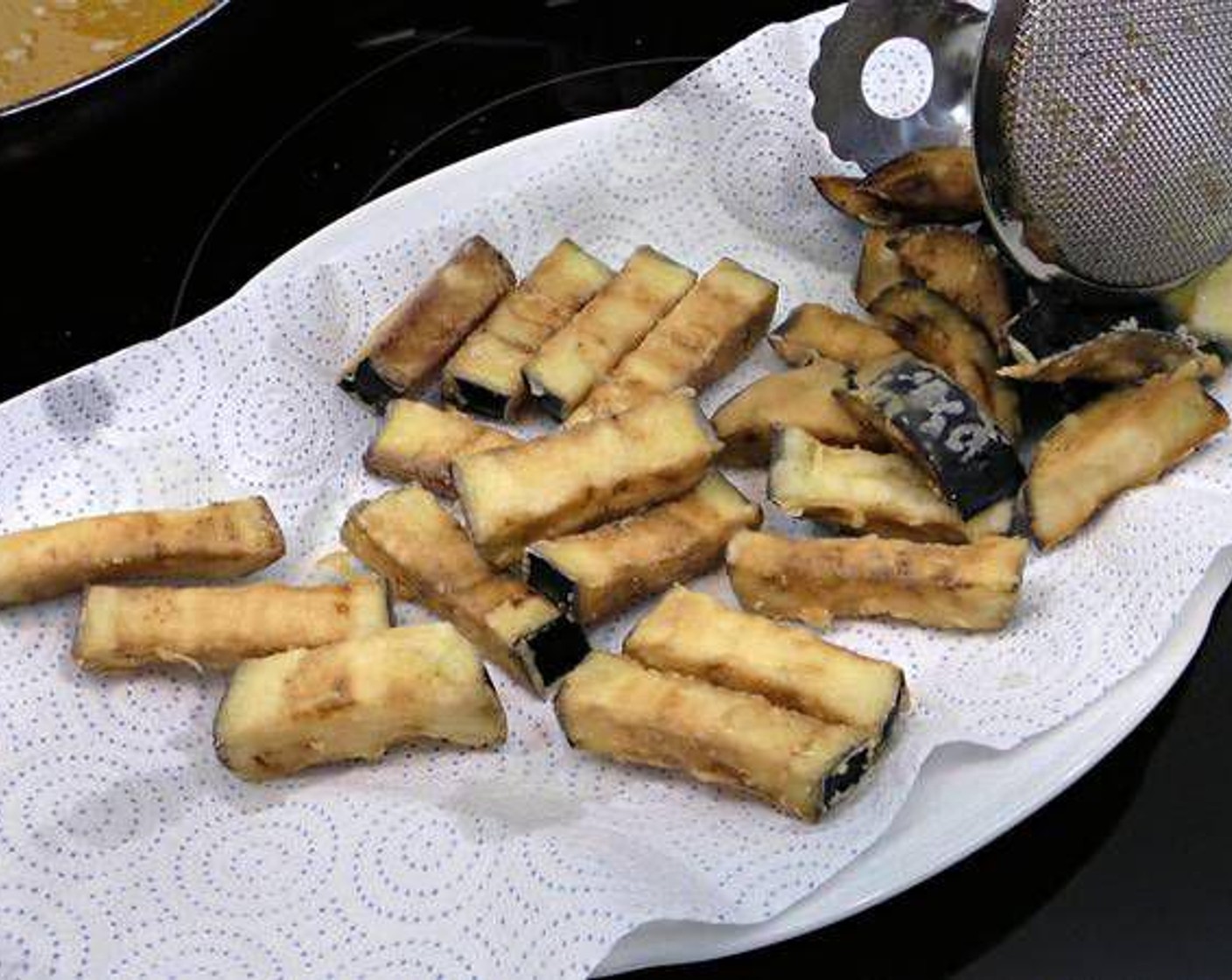 step 4 As the eggplant sticks turn golden brown, remove and place on a paper towel to dry the excess oil.