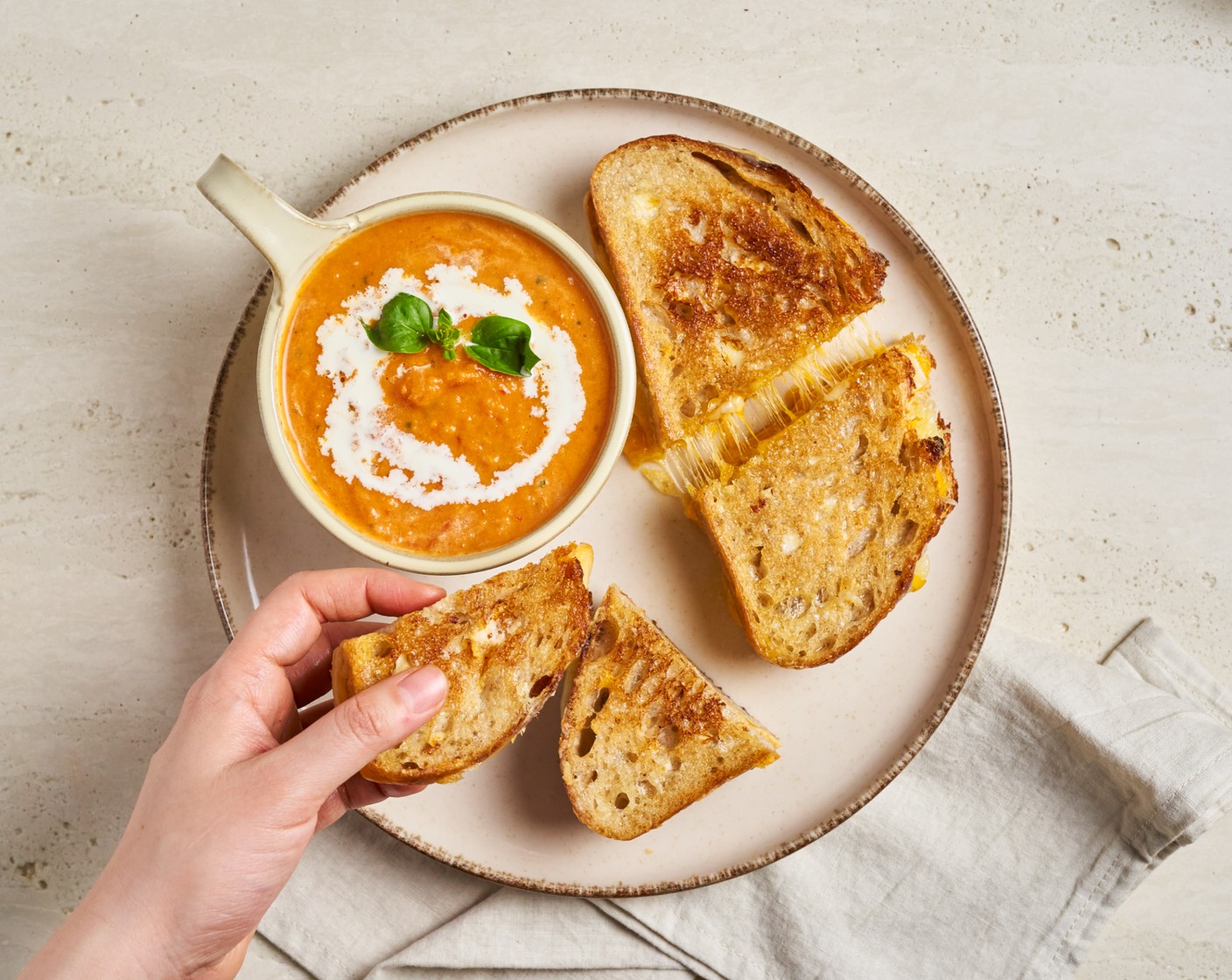 step 11 Serve the grilled cheese with tomato soup garnished with heavy cream and basil on top.