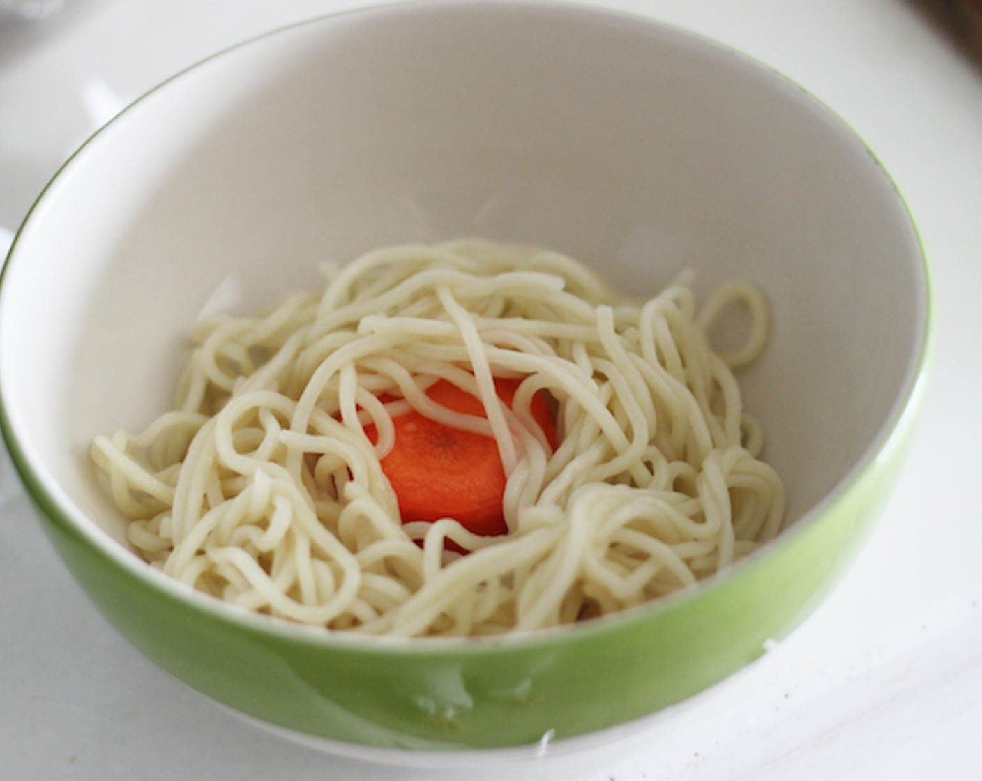 step 10 Pick up a chunk of carrot from the broth and place it in the middle for the polar bear's chair. Then wrap around the noodles.