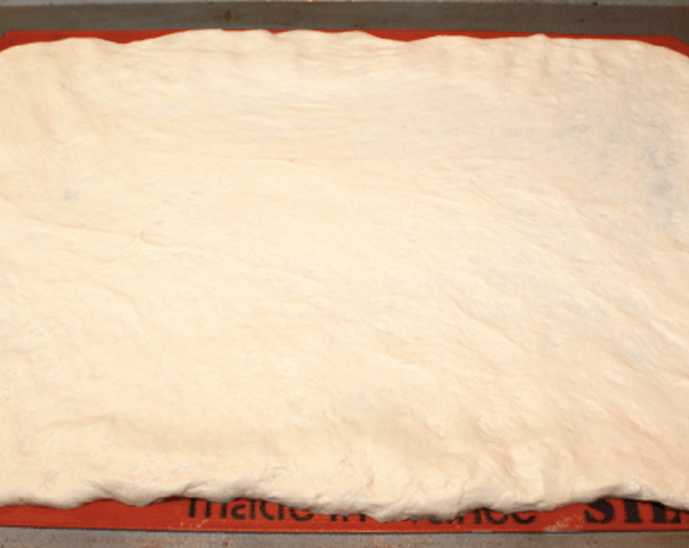 step 2 Stretch the Pizza Dough (1 lb) to roughly 11 X 16 inches or the size of a Silpat half-sheet liner. Make sure the Silpat is on a metal baking sheet.