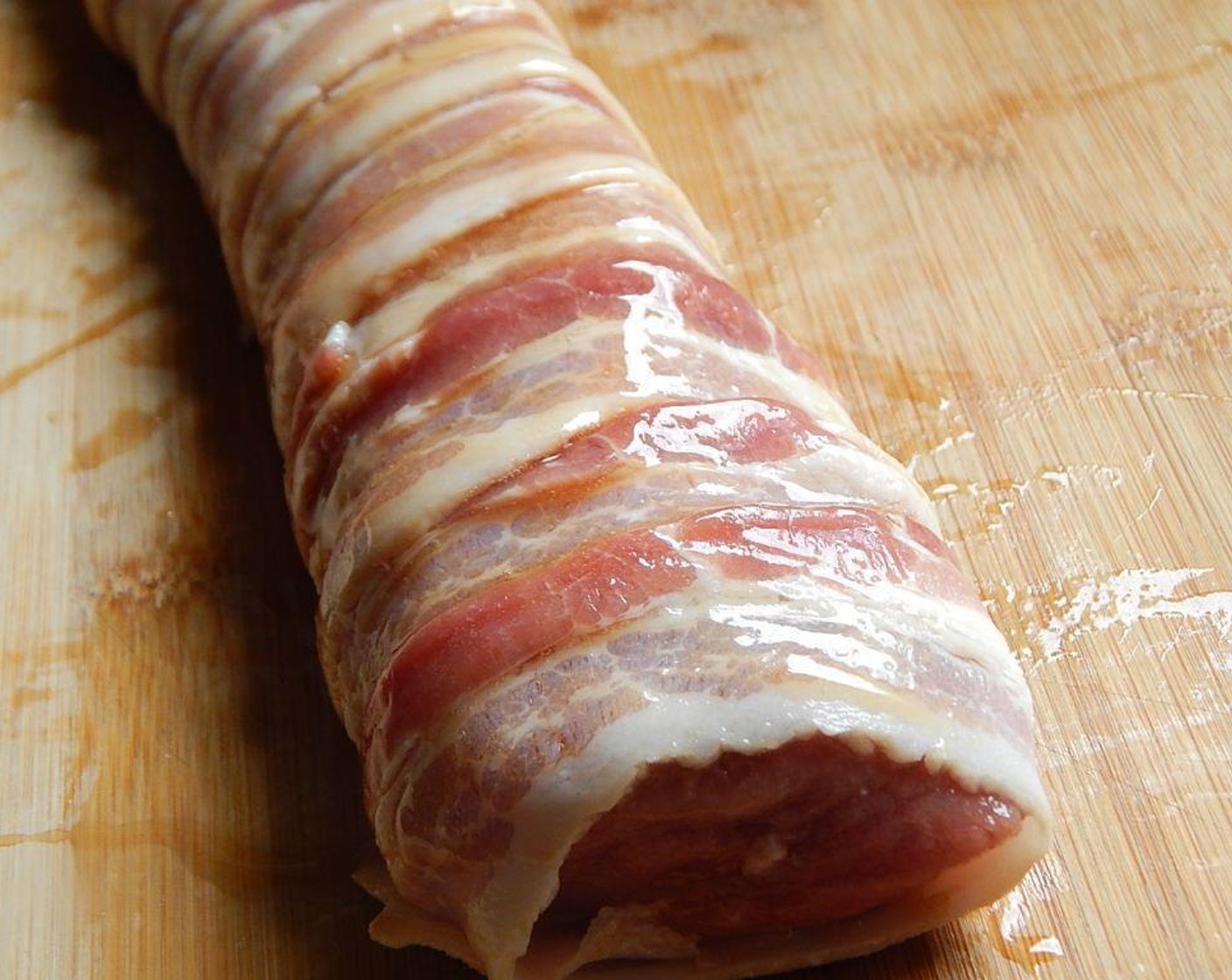 step 2 Starting from one end wrap your Bacon (8 slices) around the Pork Tenderloin (1) as tightly as you can, trying to have the ends all on the bottom. Cover bacon in the remaining syrup mixture.