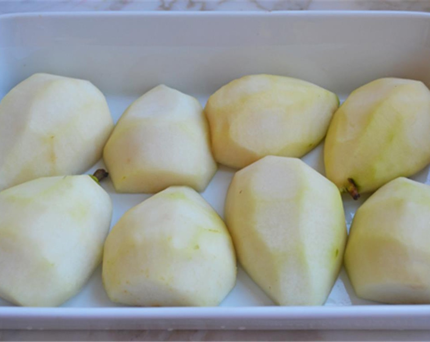 step 4 Peel and core the D'anjou Pears (4) and arrange the pears cut side down in a 9x13-inch baking dish.