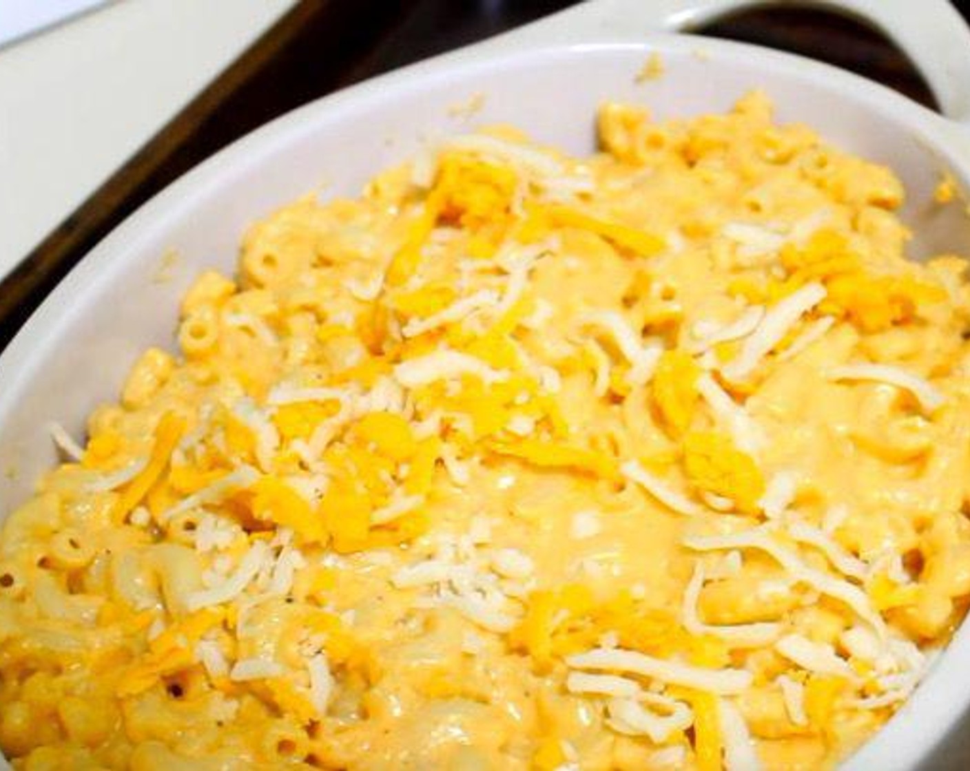 step 4 Add in cooked macaroni and mix in with sauce. Transfer to a baking dish. Sprinkle remaining cheese over top.
