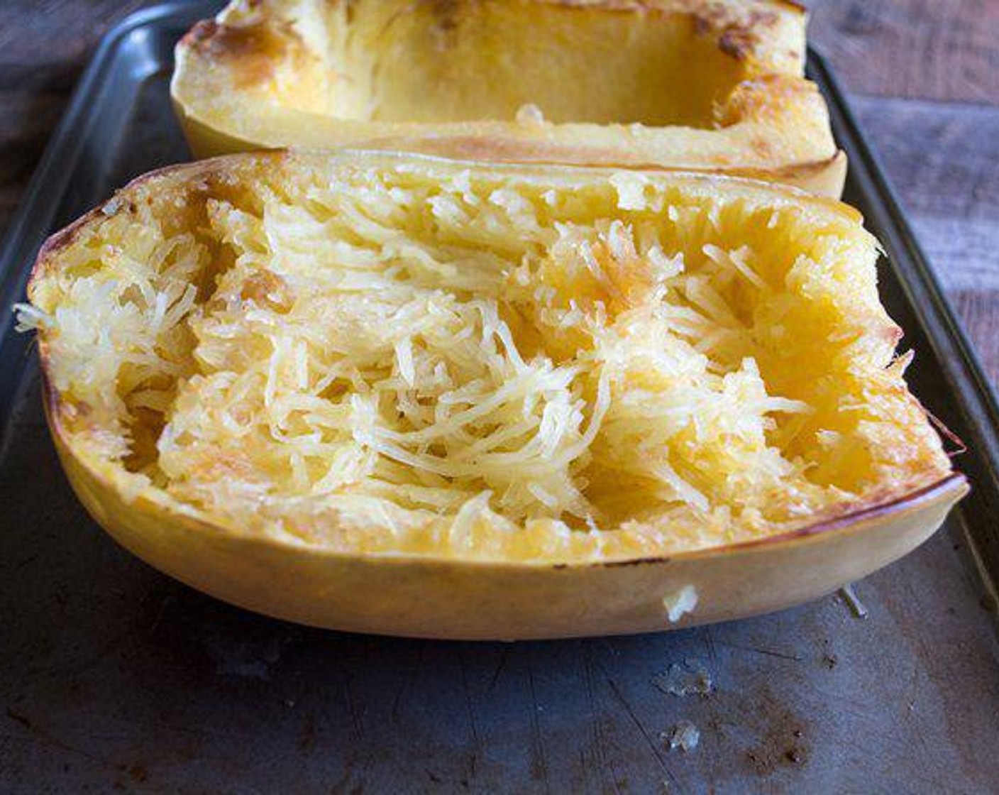 step 3 Once the spaghetti squash is cooked, remove and allow to cool 5 minutes, then scrape the flesh with a fork to loosen and separate the strands. Add strands of flesh to a bowl and discard the skins.