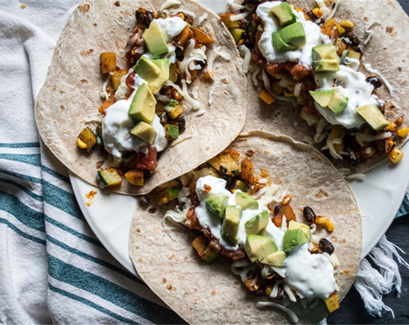 step 5 Once zucchini and black bean mix have cooked, layout Whole Wheat Tortillas (6), divide veggie mix evenly, then top with Shredded Light Mozzarella Cheese (1/2 cup) and any desired toppings - Salsa (to taste), Sour Cream (to taste), Tomatoes (to taste), and Avocados (to taste) are some of our favorites!