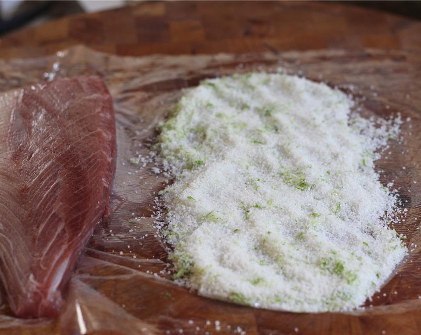 step 4 Lay out a sheet of plastic wrap twice the length of the fish being cured. Evenly spread out a layer of half the curing mixture in the middle of the plastic the length of the fish.