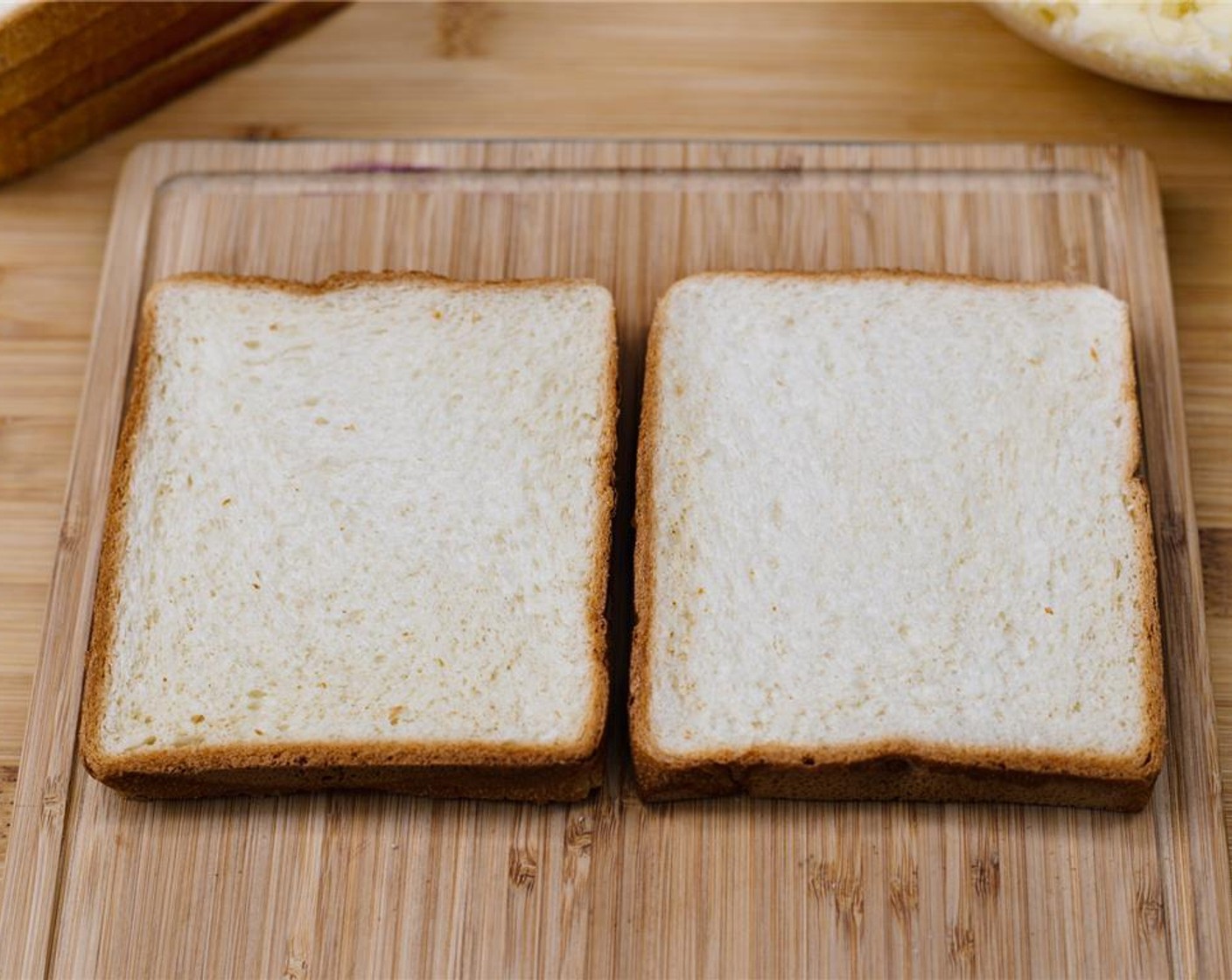step 3 Place two slices White Sandwich Bread (12 slices) next to one another on a wooden chopping board.