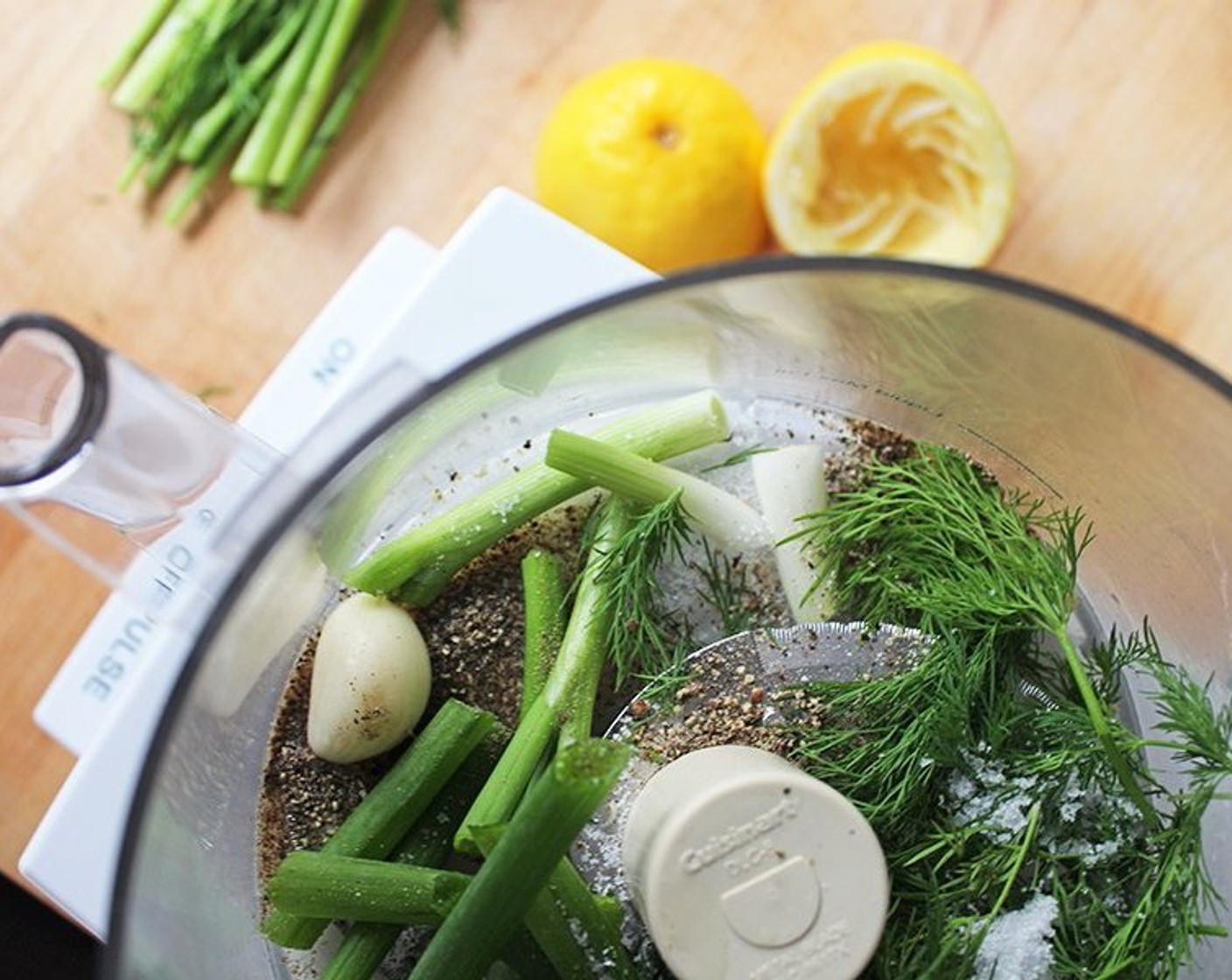 step 1 Place Fresh Dill (1 cup), Scallion (1 bunch), Garlic (2 cloves), Kosher Salt (1 tsp), Ground Black Pepper (1/2 tsp), Lemon (1), 2 Tbsp of Lemon Juice, and White Wine (1 Tbsp) in the bowl of a food processor fitted with the blade attachment. Process until the mixture is finely chopped.