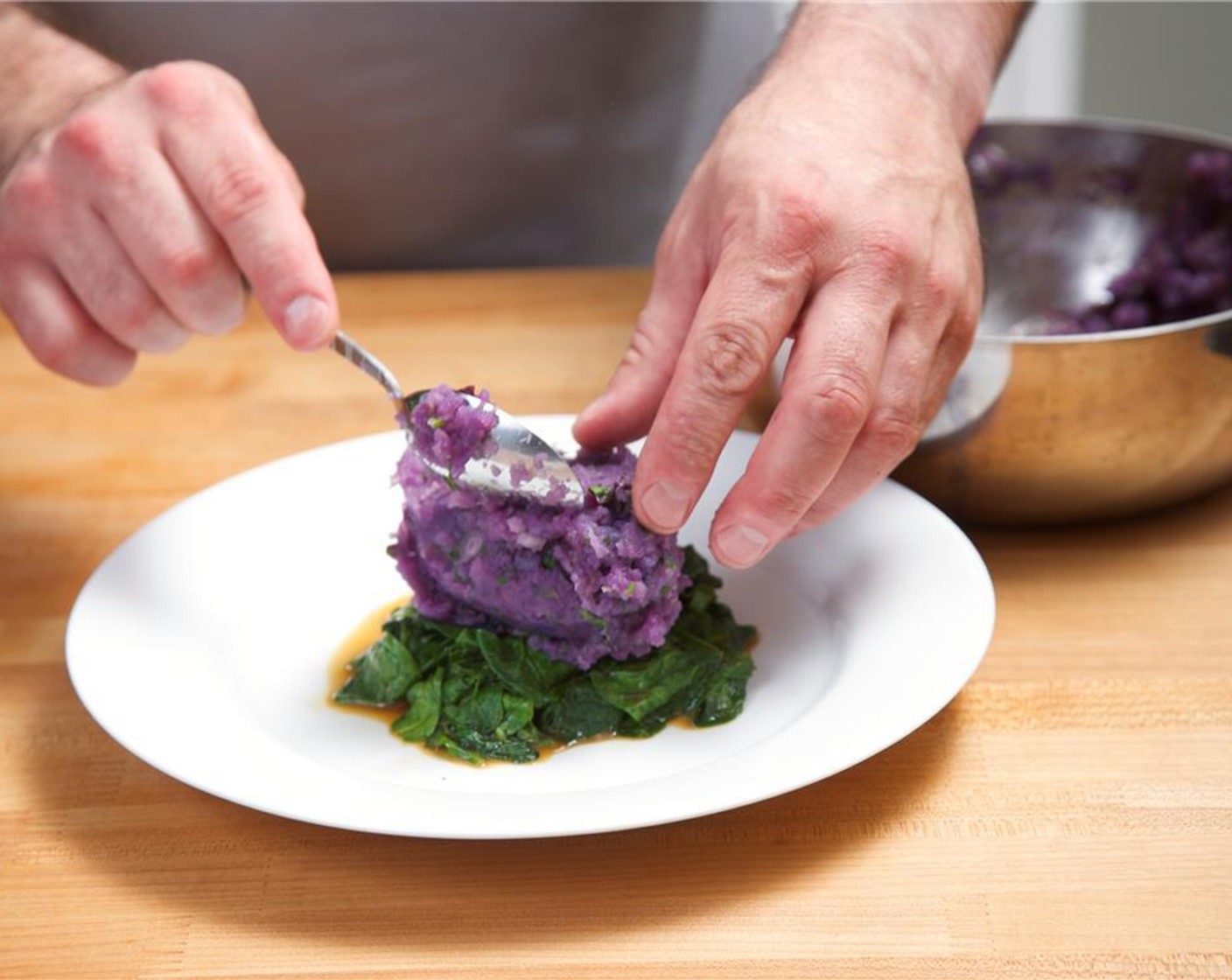 step 11 Plate a bed of wilted spinach in the center of 2 plates. Place smashed potato in the center of the top of the spinach with height.