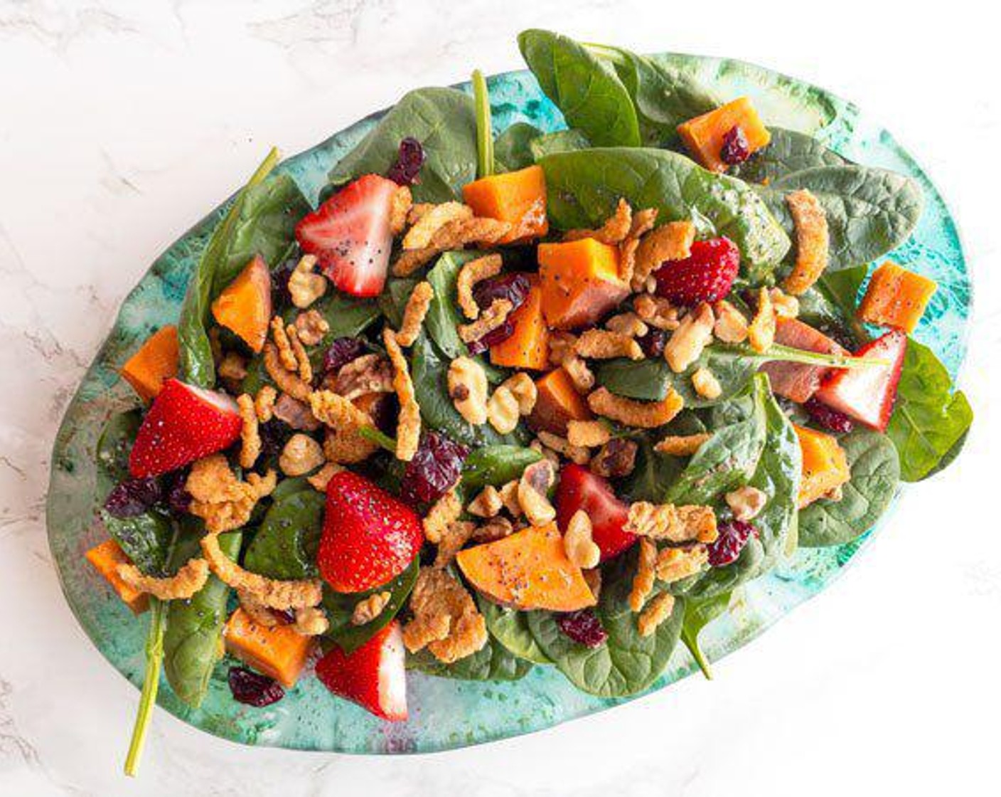 step 3 Add Fresh Spinach (1 pckg) to a large bowl or platter. Add Fresh Strawberries (2 cups), Fried Onions (1 cup), Dried Cranberries (1/4 cup), and Walnut (1/4 cup). Stir dressing and add just before serving. Enjoy!