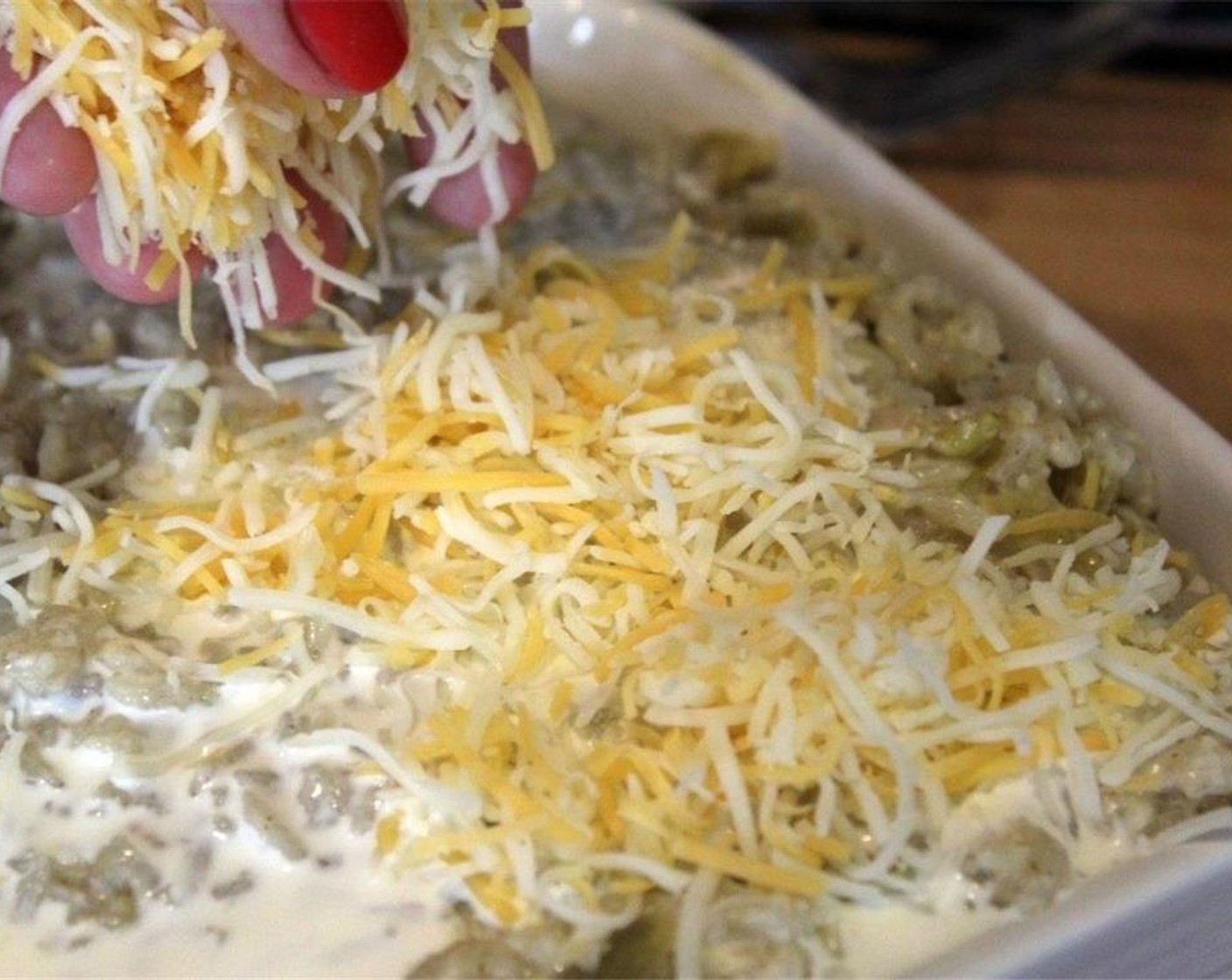 step 11 Now, spread the mixture into a baking dish, and sprinkle the rest of the Shredded Cheese (1/2 cup) all over the top.