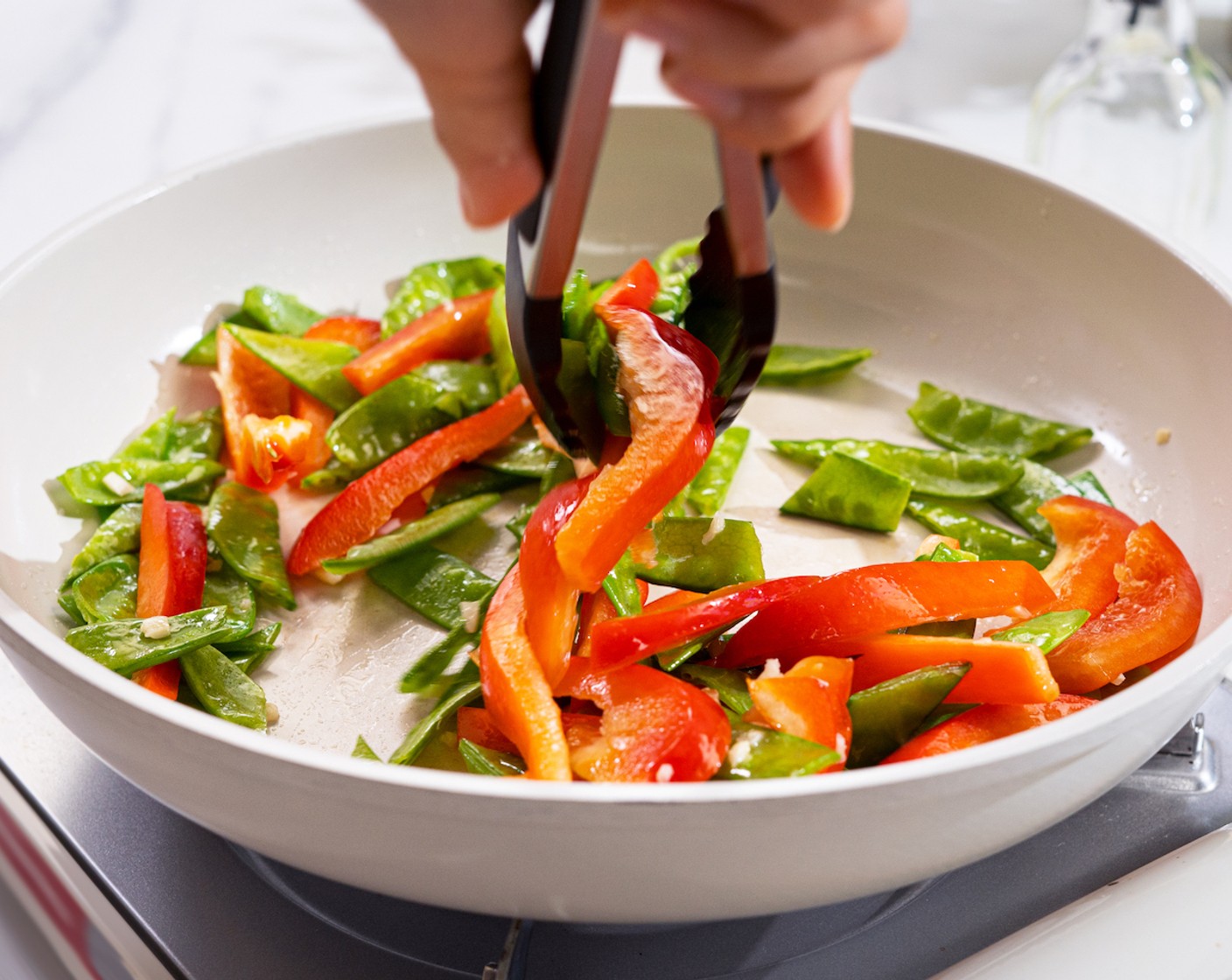step 2 Heat the frying pan with Vegetable Oil (1 Tbsp). Once hot, add another Garlic (2 cloves), Snow Peas (3/4 cup), and Red Bell Pepper (1). Stir fry for 2-3 minutes. Remove from the pan, and set aside.